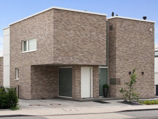 Zur Straße tritt die Villa zweigeschossig mit geschlossener Fassade in Erscheinung