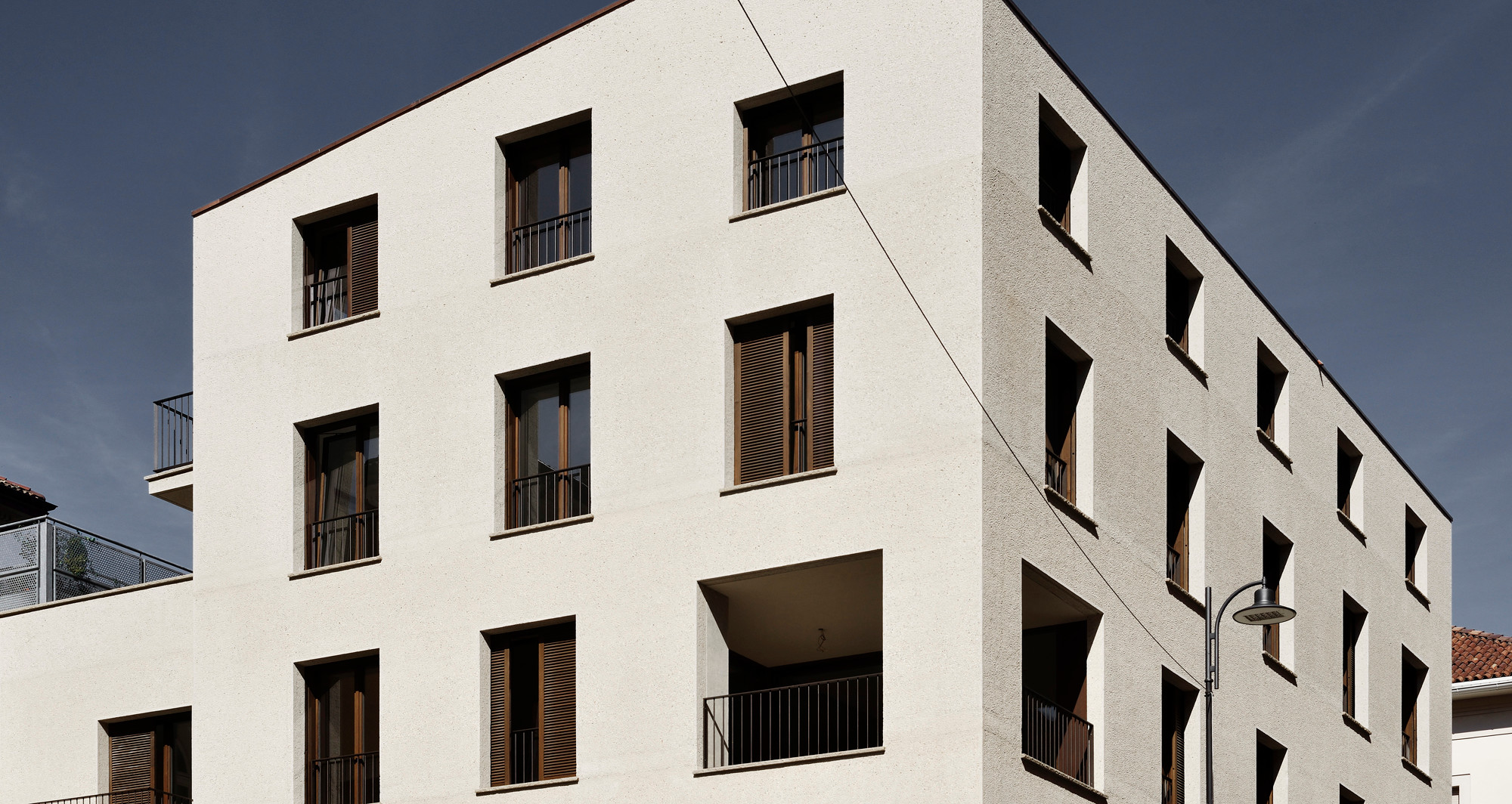 Französische Fenster und Holzschiebeläden prägen die Außenwirkung des Wohn- und Geschäftshause