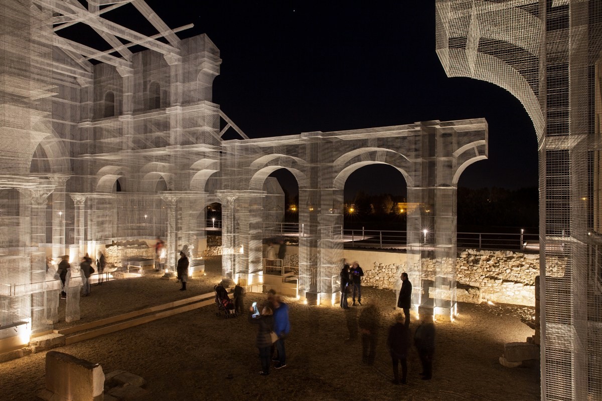 Die offene netzartige Struktur des Metallgewebes formt einen lichten, fast immateriellen Kirchenraum mit Säulen, Gewölben und Figuren