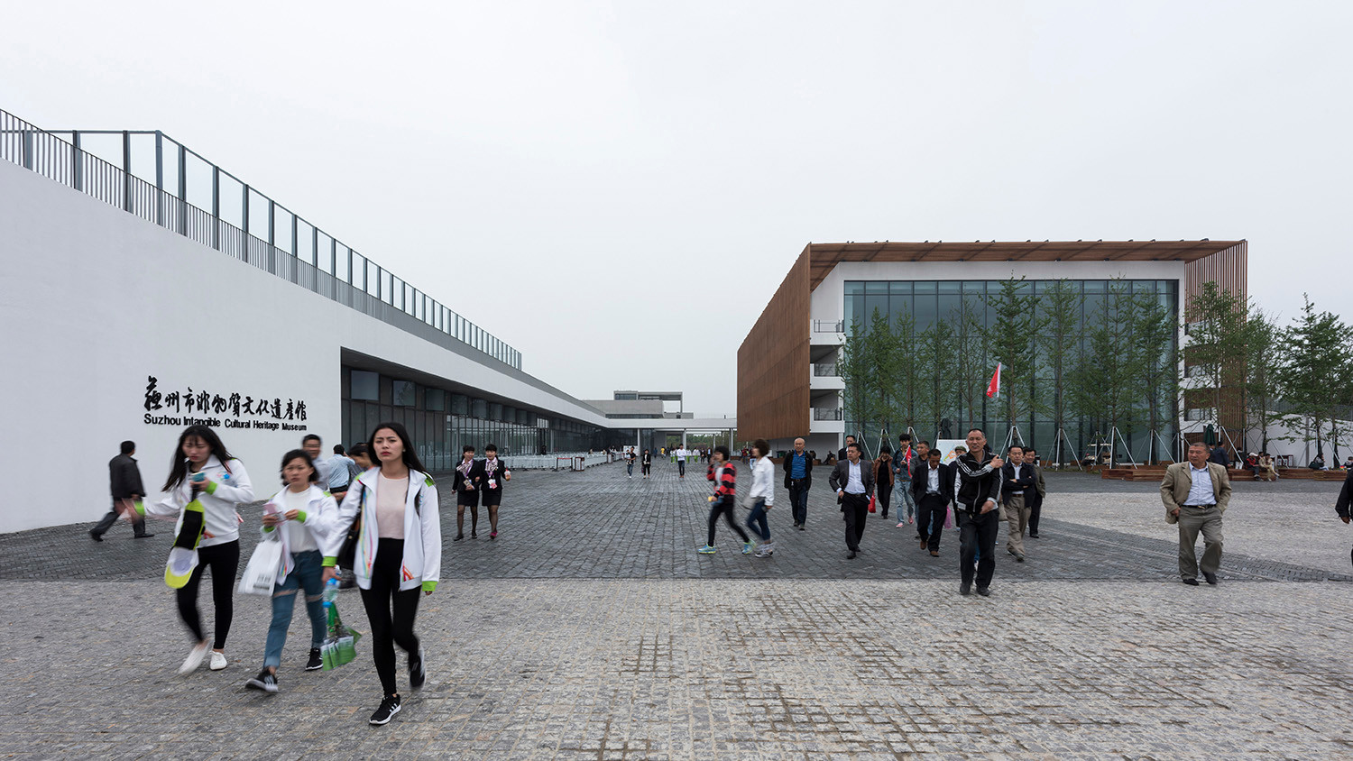 Ein zur Straße im Norden ausgerichteter Platz bildet die Eingangssituation, seitlich gefasst durch das lang gestreckte Ausstellungsgebäude und die gläserne Front des aufragenden Theaters