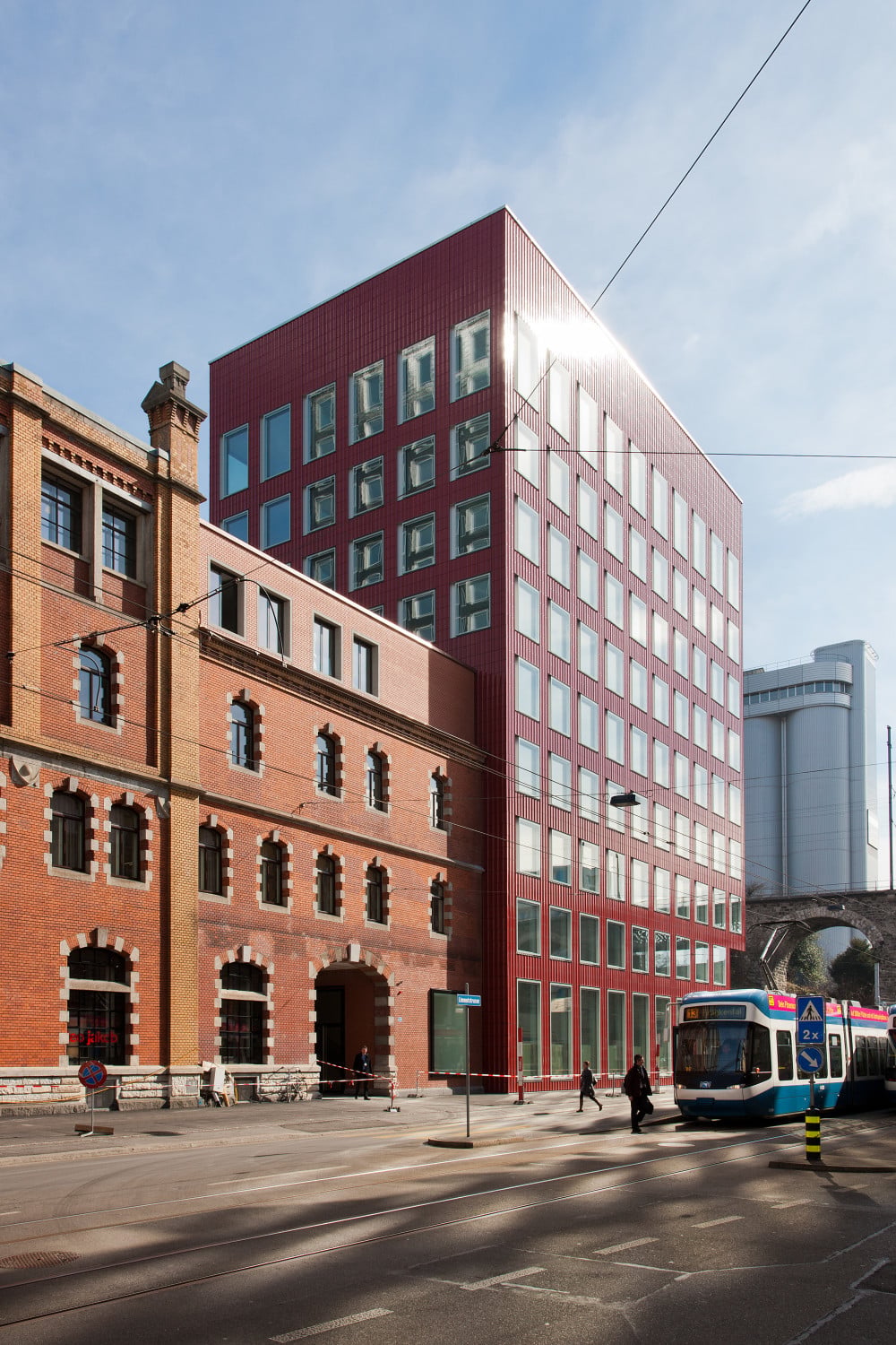 Die schimmernden Keramikfassaden des Wohnturms und des roten Bürogebäudes sind zum neuen Markenzeichen des Areals geworden