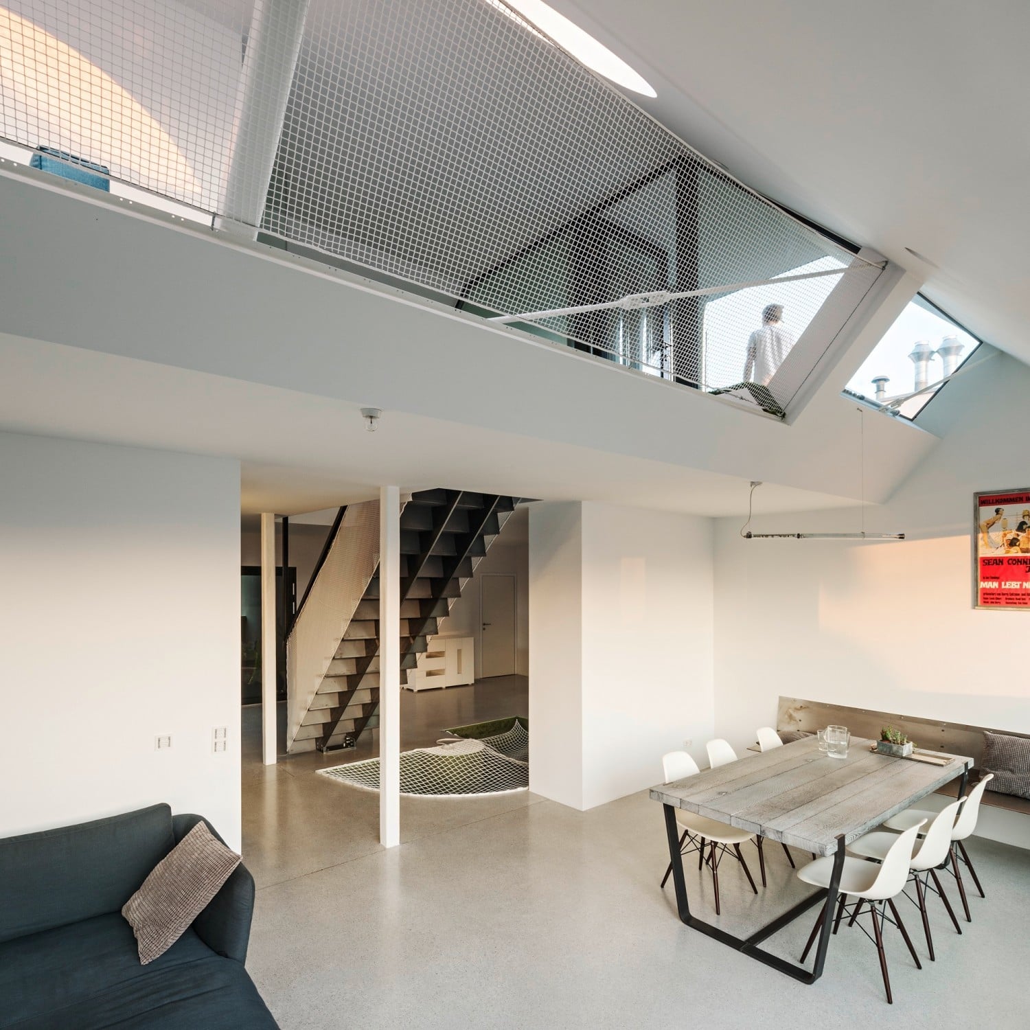 Blick vom Wohnraum zur Galerie auf der oberen Etage, die durch ein weißes Fangnetz gesichert ist