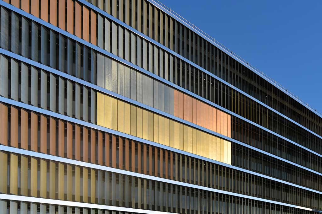 Geschlossen und in die Fassadenebene gedreht ergeben die Glaslamellen eine opake, fünffarbige Fassade 