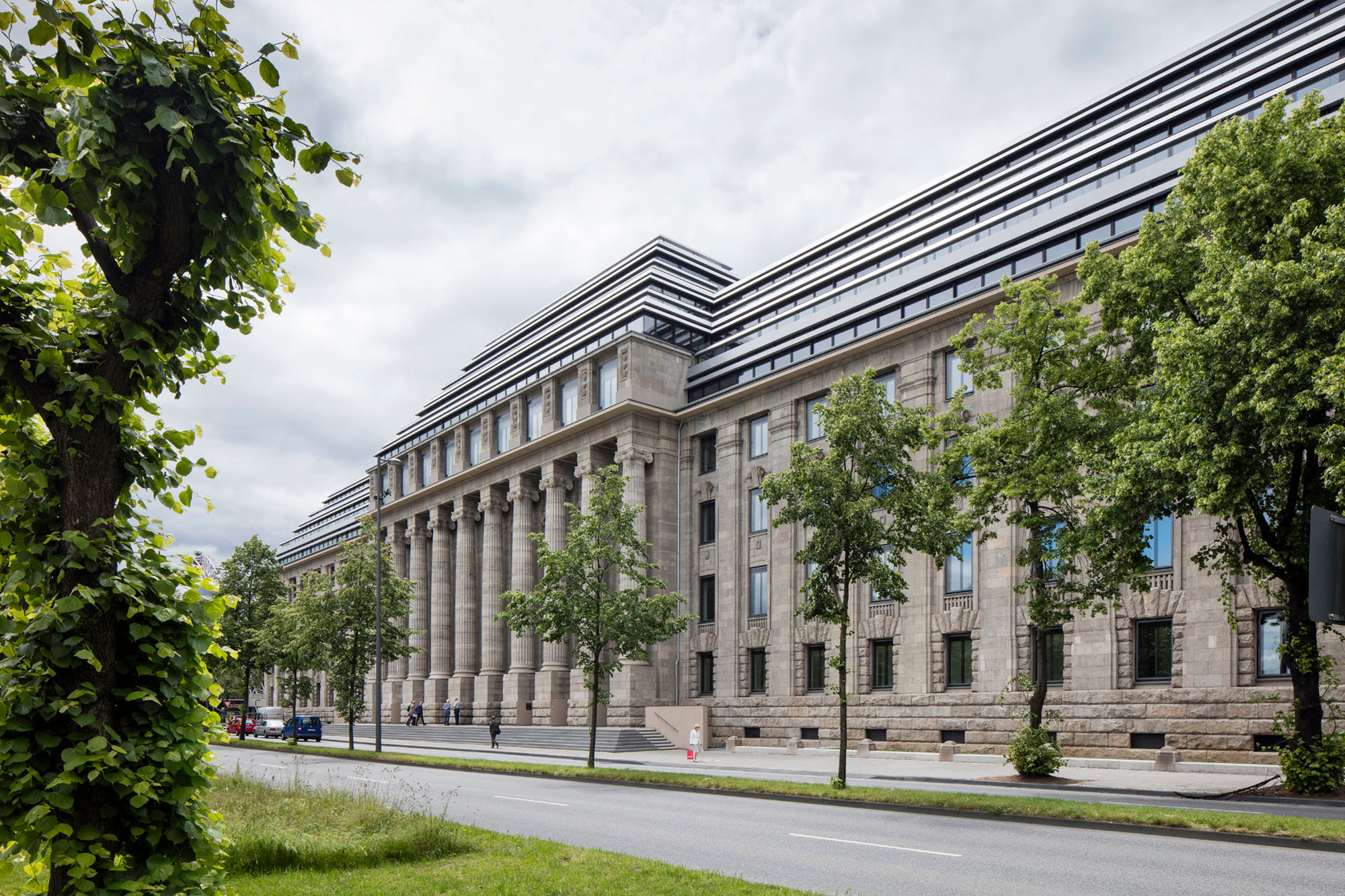Mit einer stringent horizontalen Linienführung und einer gegensätzlicher Materialität in Glas und Metall hebt sich der Dachaufbau vom Bestand deutlich ab