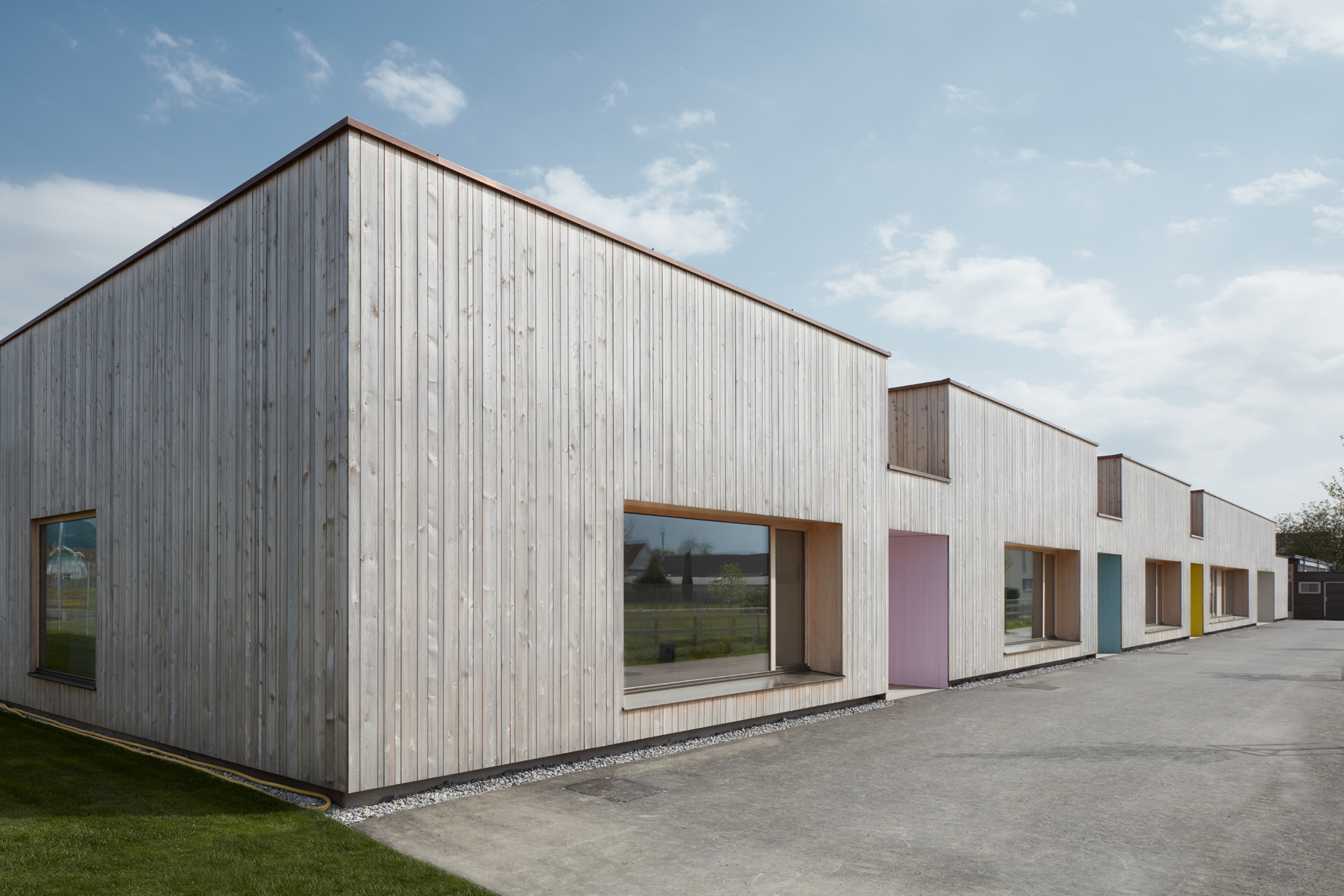 Liebevoll auch "Raupe" genannt, beherbergt der eingeschossige Neubau mit drei zinnenartigen Einschnitten das Kinderhaus am Entenbach (Abb. Einggangsseite West)