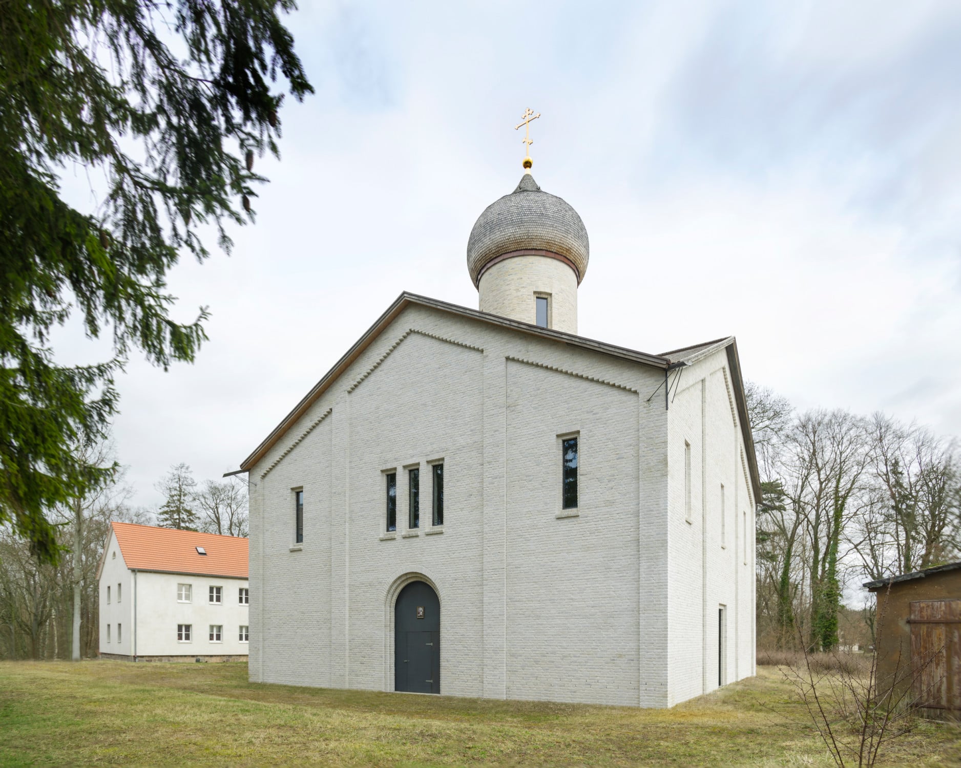 Zweifache Gewände um den Haupttürbogen, zurückspringenden Faschen und Lisenen verleihen den Fassaden eine dezente Tiefe