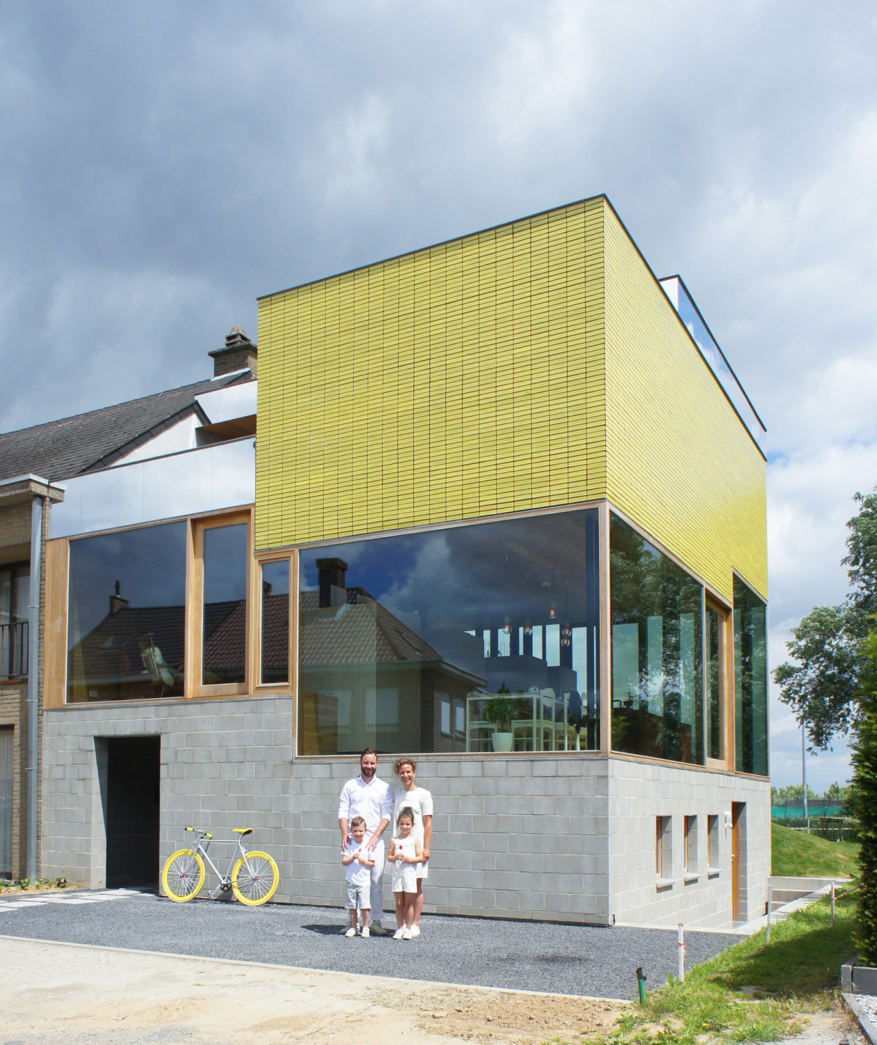 Das Haus hebt sich durch sein Flachdach und die markanten gelben Klinker im Obergeschoss von der Nachbarbebauung ab