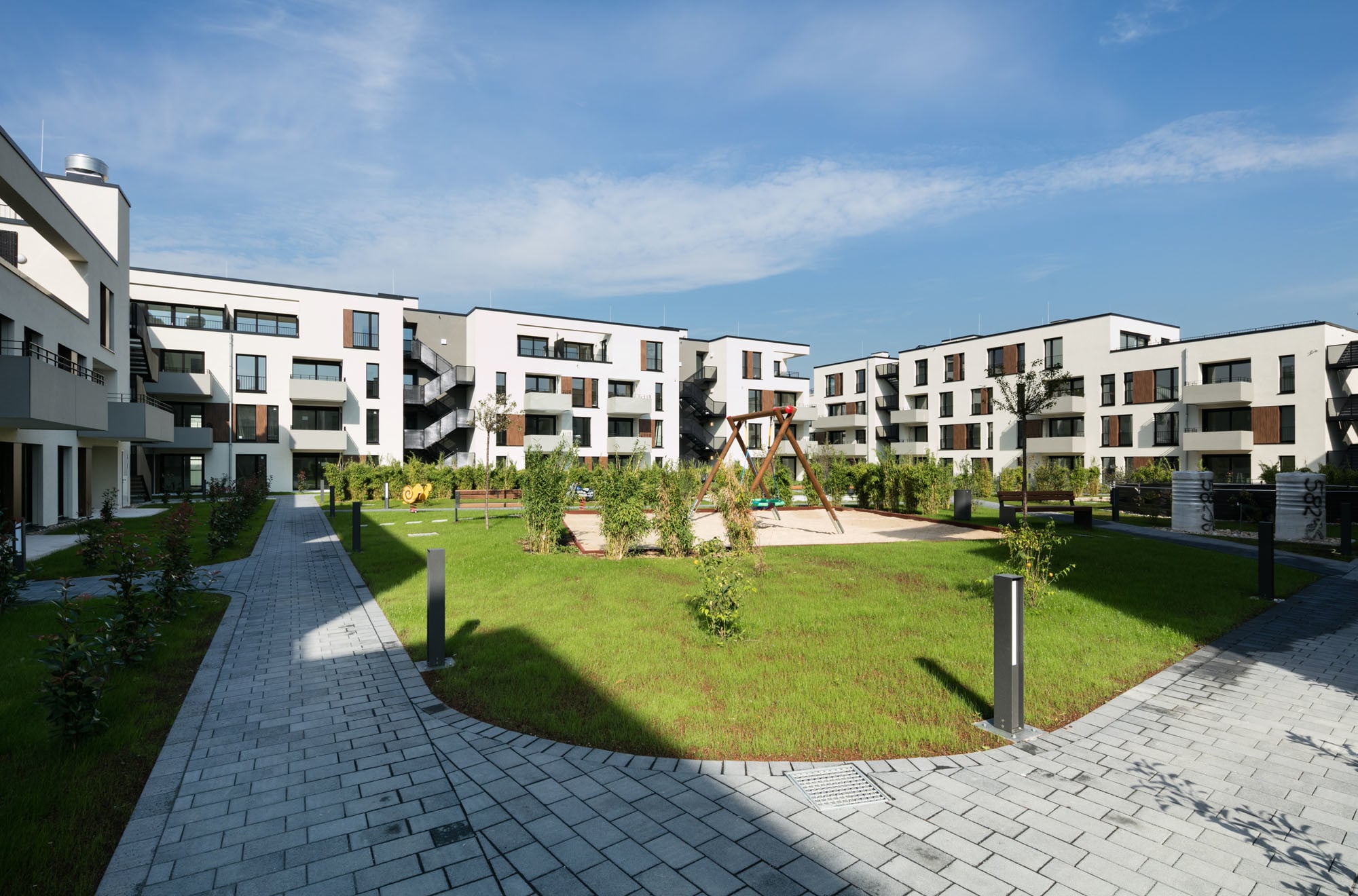 Oberhalb der gewerblichen Nutzung umfassen viergeschossige Baukörper einen begrünten Hof