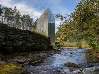 Unmittelbar am Wasserlauf wird das Toilettenhäuschen nach Plänen von Fortunen Arkitektur zum Blickfang