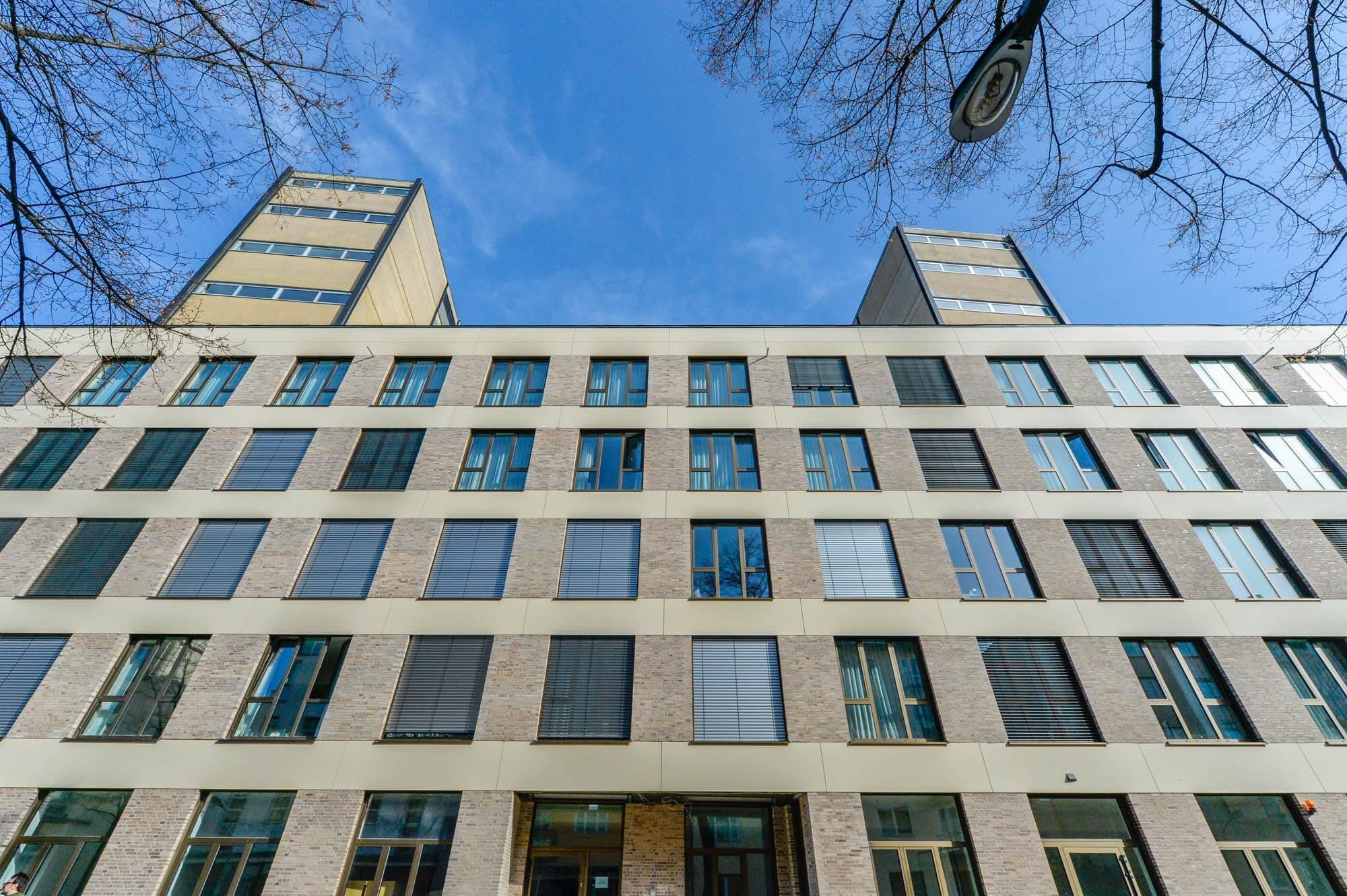 Fassade des Neubaus mit den dahinter liegenden alten Treppentürmen: Insgesamt wurden 238 sogenannte Mikroapartments untergebracht