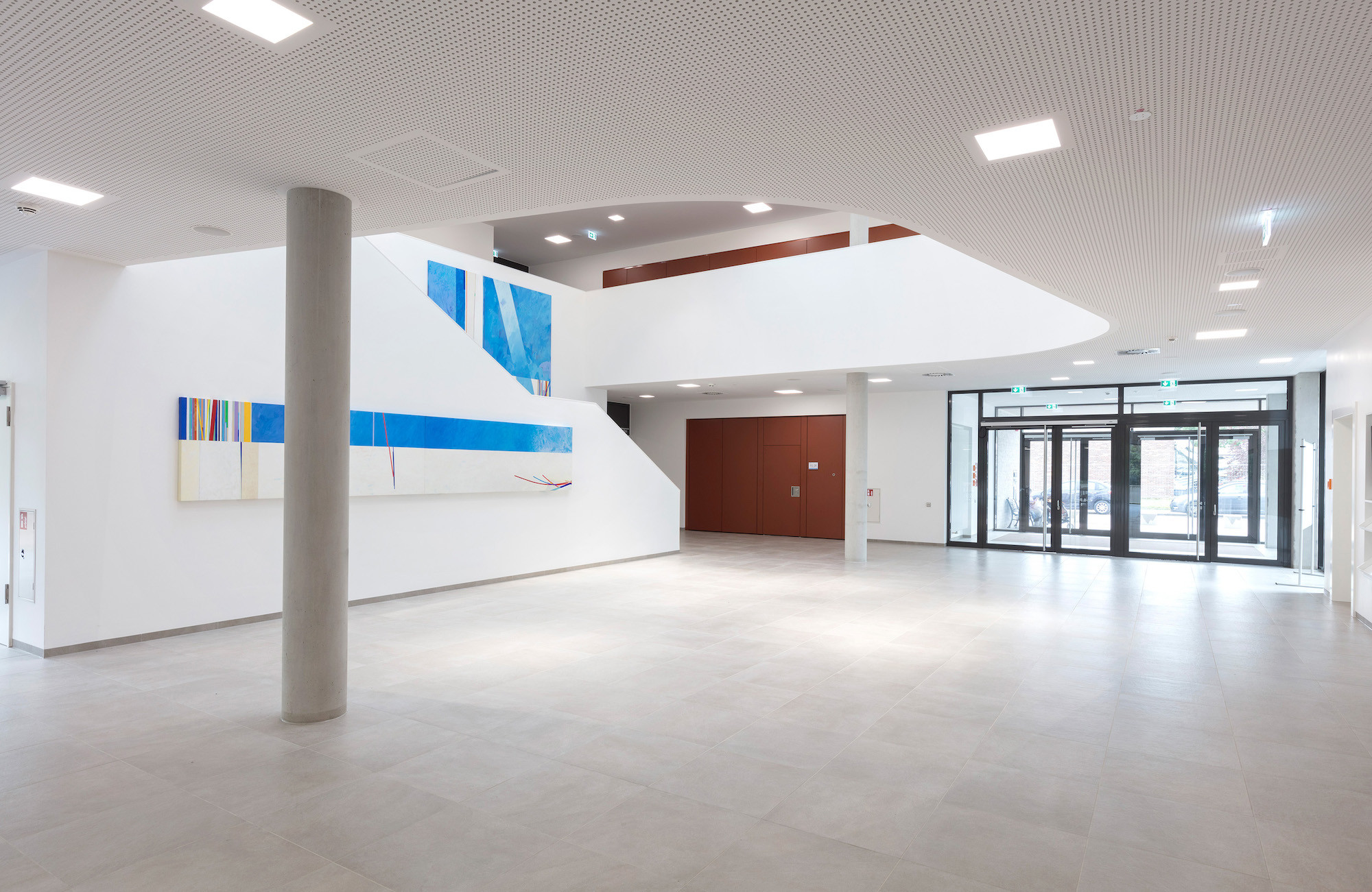 Die beiden zweigeschossigen Baukörper durchdringen sich in einem zentralen Foyer
