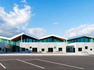 Prägendes Element der beiden Schulgebäude ist eine Abfolge unterschiedlich geneigter Satteldächer mit großen, unregelmäßigen Dachüberständen