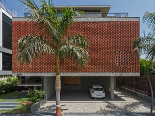 Das Architekturbüro Design Group Work realisierte mit dem Brick Curtain House ein Wohnhaus mit gemauerter, geschwungener Vorhangfassade