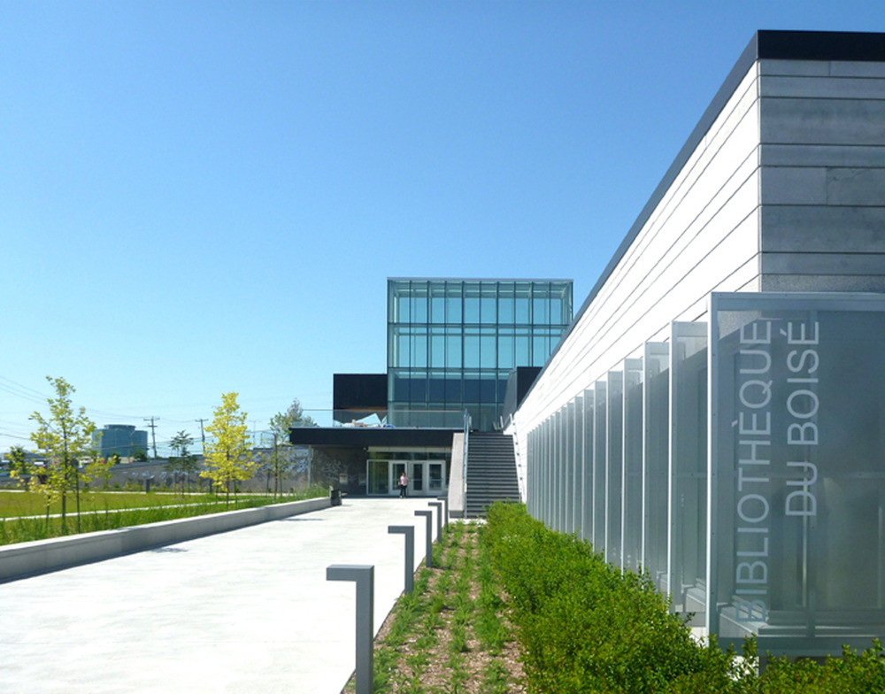 Der Zugang zur Bibliothek erfolgt im Erdgeschoss über ein zentrales Atrium mit einem Glasaufbau, der weit über das Gebäude hinausragt