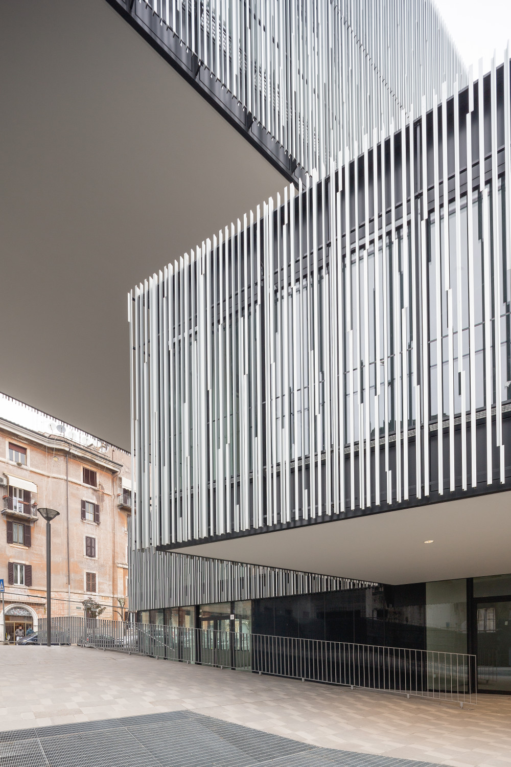 Durch die Gliederung der Baumasse und die kleinteilige Gestaltung der Außenräume gelang es den Architekten, den modernen Gebäudekomplex eng mit der Umgebung zu verzahnen