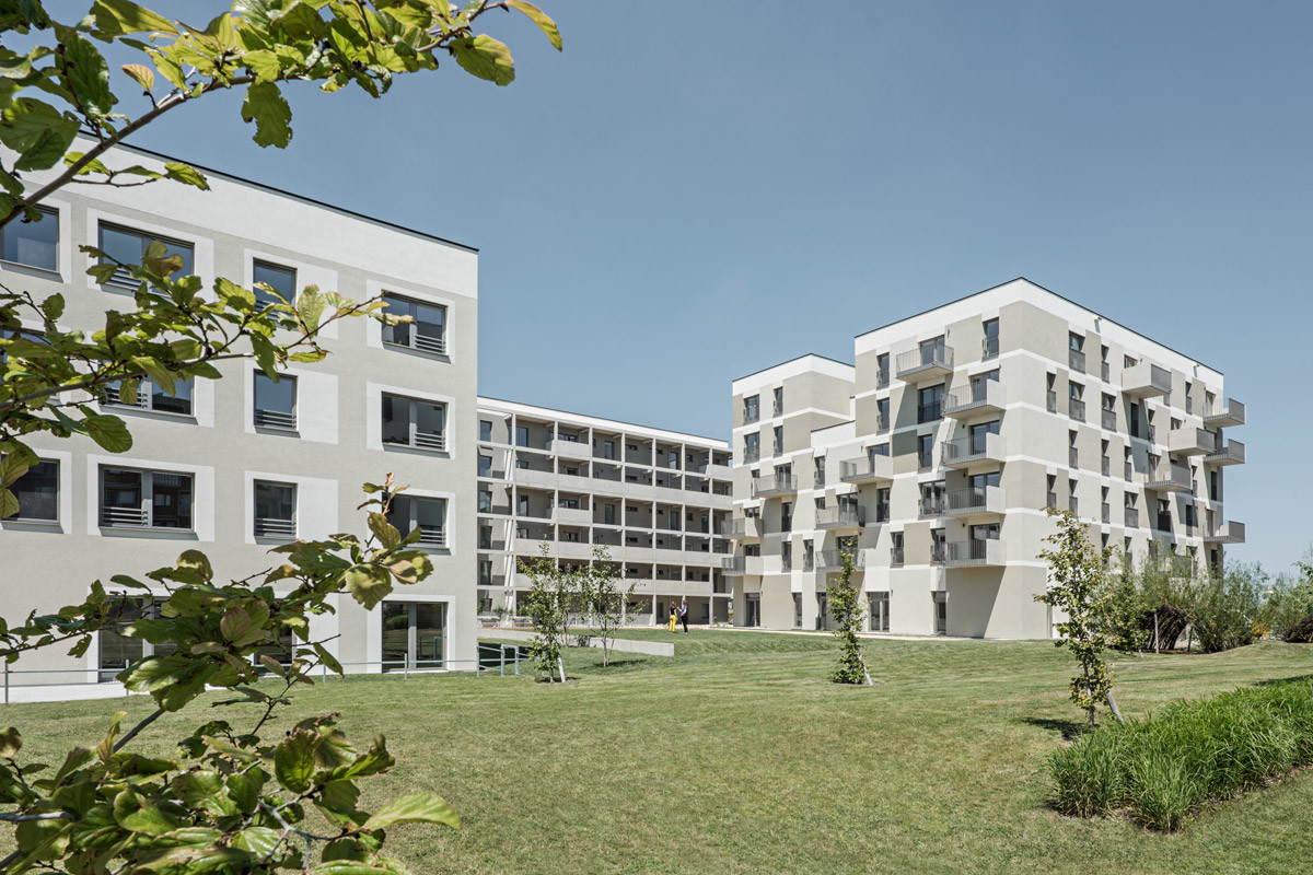 Das Ensemble von Südosten: Links das viergeschossige Wohnheim für behinderte Kinder und Jugendliche, im Hintergrund der Gebäuderiegel mit Mietwohnungen und rechts das kompakte Wohnhaus der Baugruppe