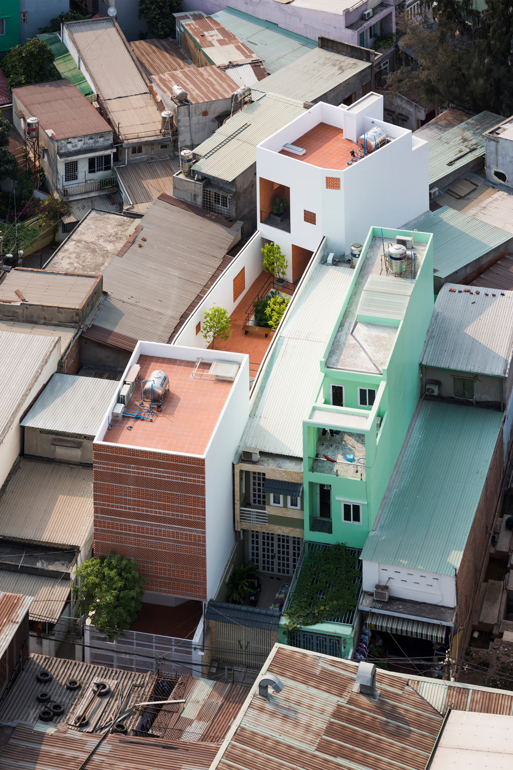 Die Architekten entwickelten für den lang gestreckten Bauplatz, der im Norden leicht abknickt, eine introvertierte Lösung: An den schmalen Stirnseiten wurde jeweils ein dreigeschossiger Baukörper platziert