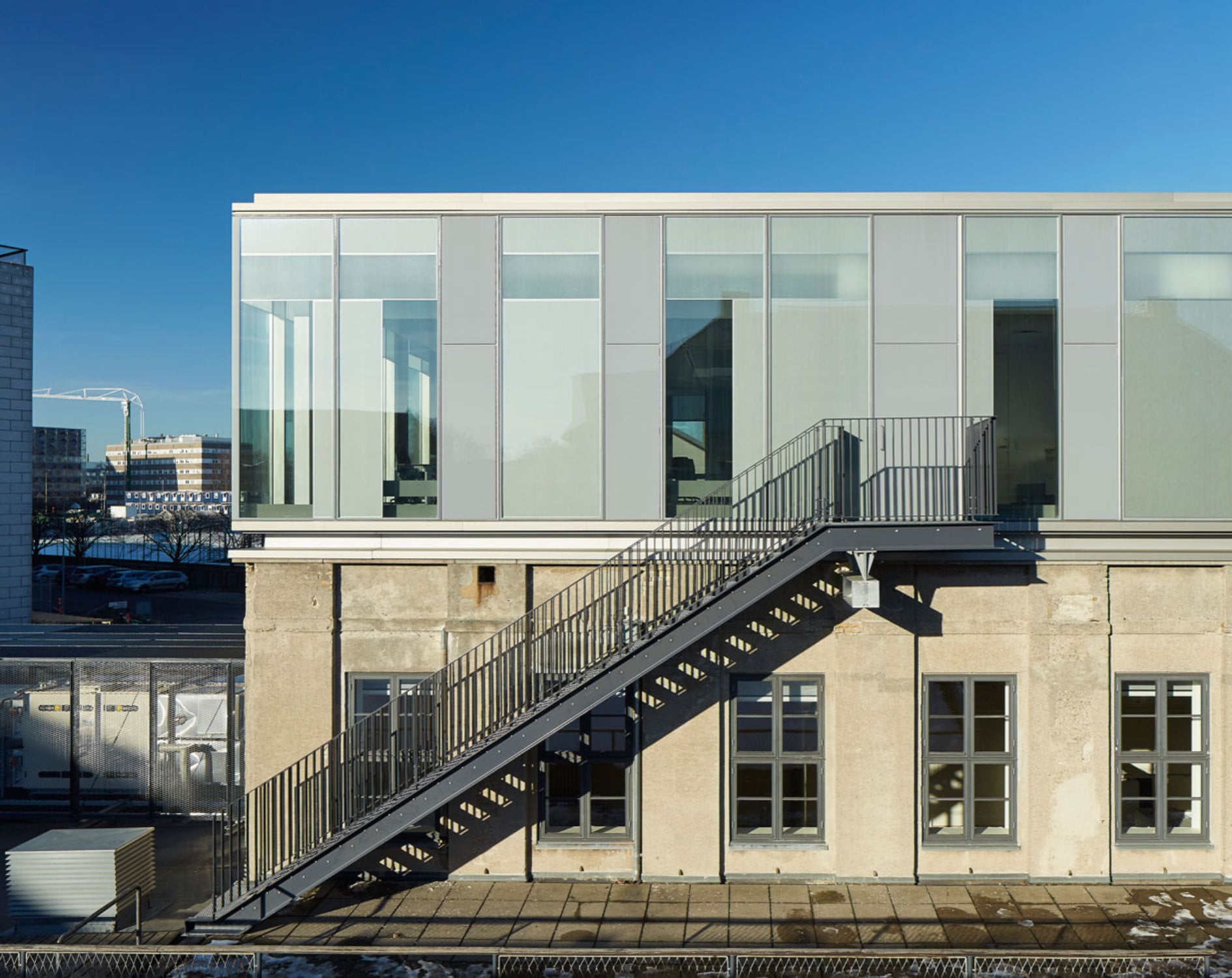 Die Architekten stockten den Flachbau um ein gläsernes Dachgeschoss auf