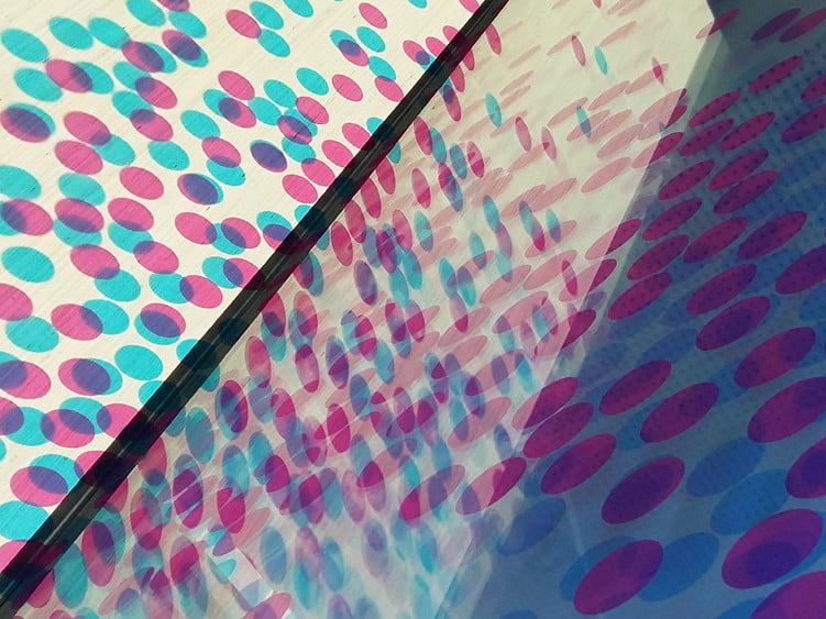 Cyanblaue und magentafarbene Punkte leuchten auf, silbrige Lichtblitze huschen durch die Räume, wenn die Sonne auf die gläserne Fassade der sogenannten Funkstation in München fällt