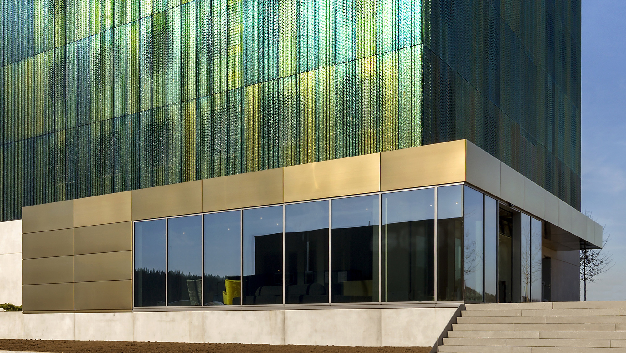 Der Stahlbetonbau hat eine vorgehängte Metallfassade aus gelochten Edelstahlblechen mit anodisierter Oberfläche