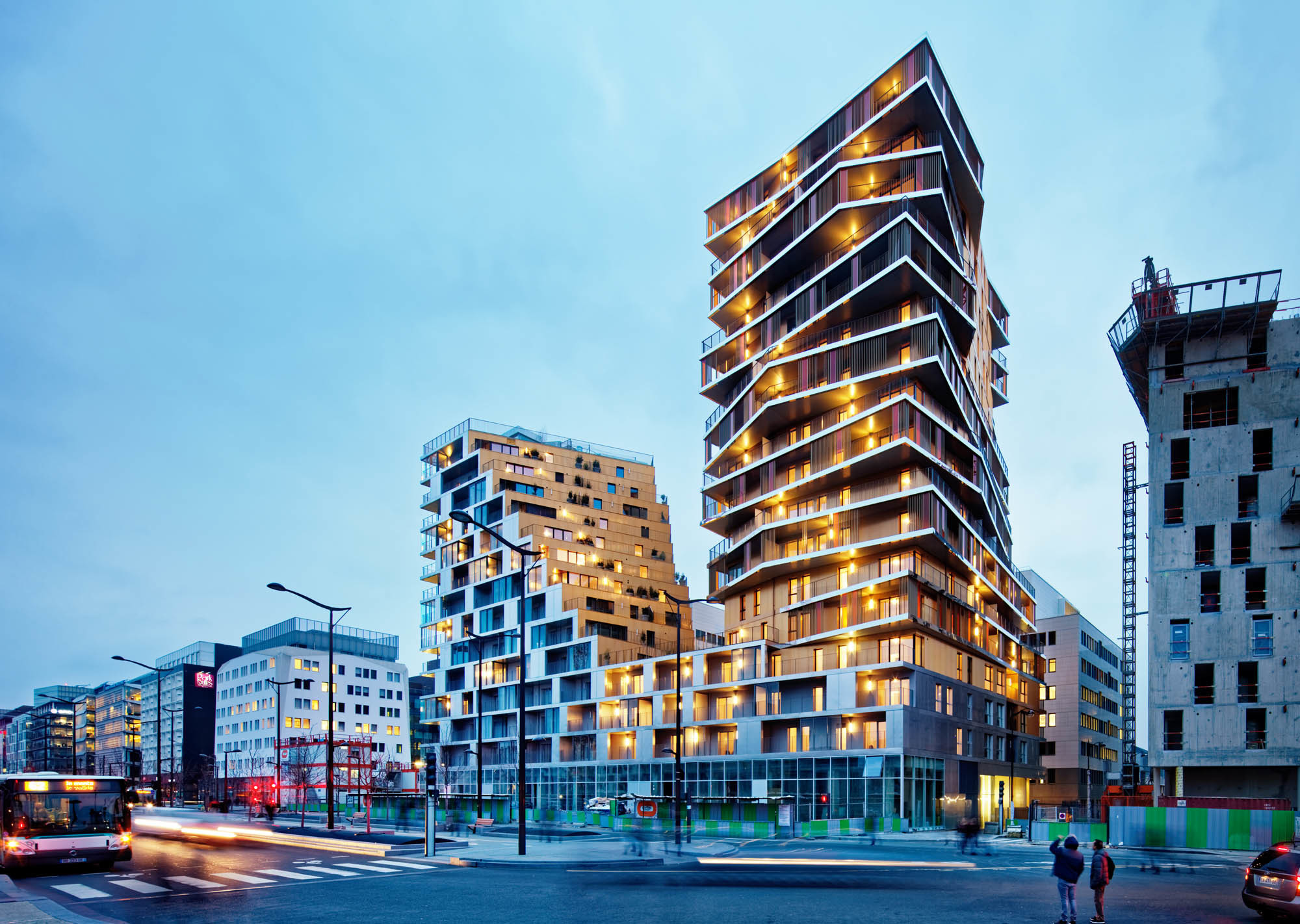 Diese augenscheinliche Vielfalt wird glanzvoll inszeniert durch eine Hülle aus eloxiertem Aluminium in hellem Gold und Silber, die zu jeder Tages- und Nachtzeit anders schimmert