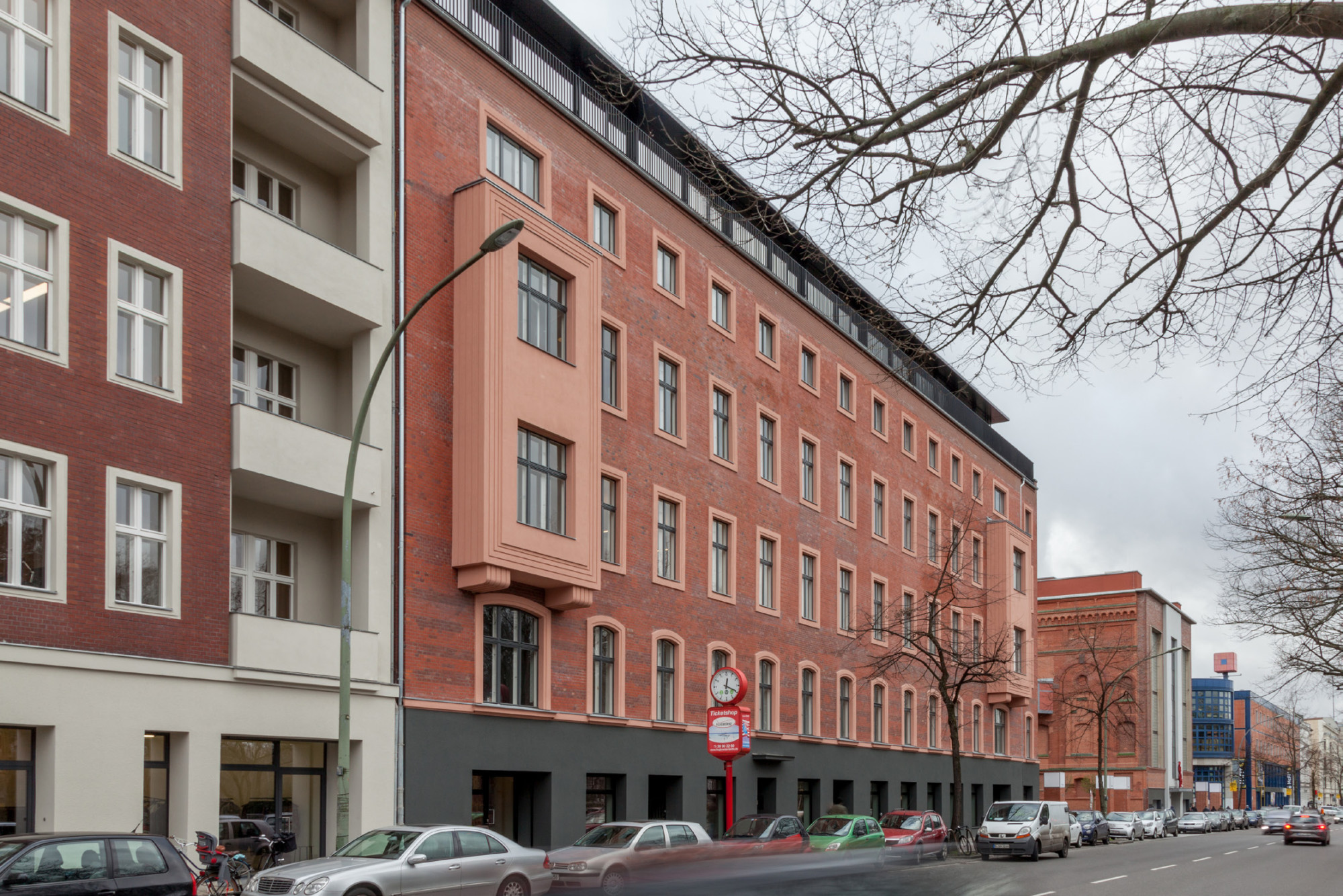 Die ursprünglich zweigeteilte Straßenansicht wandelte sich in eine dreigliedrige, mit dunklem Sockel, viergeschossiger Backsteinfront und dem mattschwarz gerahmten verglasten Staffelgeschoss als oberem Abschluss
