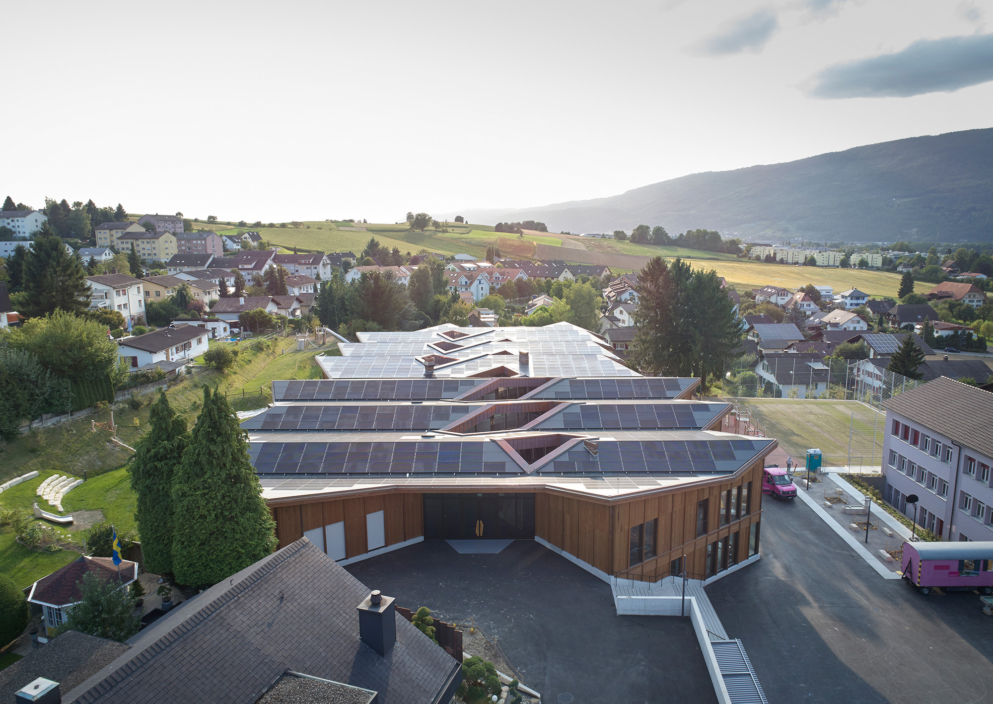 Mit einem gegenüberliegenden Altbau aus der Nachkriegszeit ist das Schulhaus nach Plänen des Zürcher Architekturbüros Skop durch einen Pausenhof verbunden