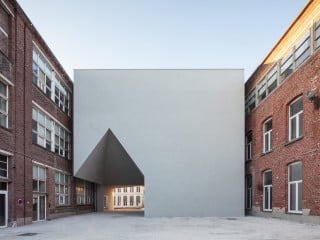 Zeichenhafter Eingangsbau der Architekturschule zwischen den Bestandsbauten einer ehemaligen Fabrik