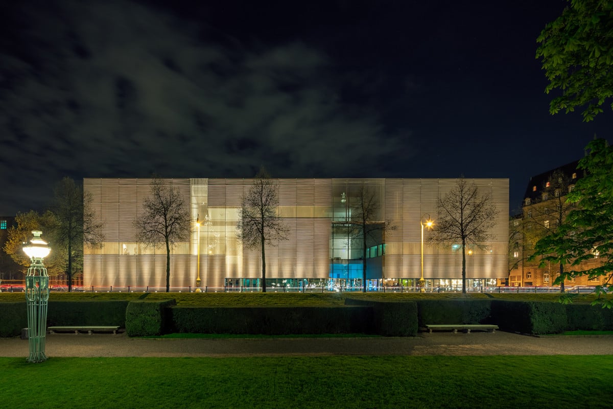 Eine partiell unterschiedlich durchlässige Metallhülle bildet die äußere Fassade des Museums