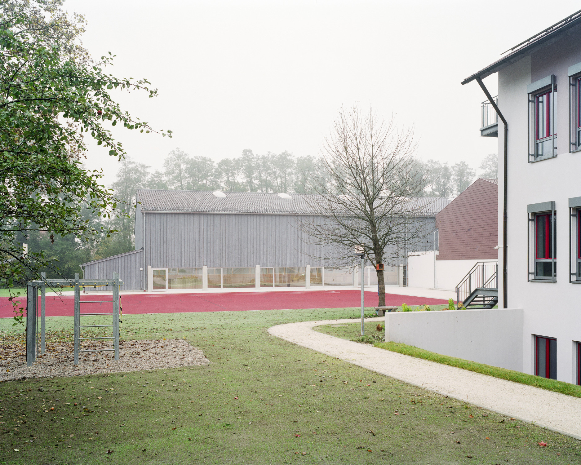 Südliche Eingangsseite der Sporthalle mit dem Haupthaus der Grundschule im Vordergrund