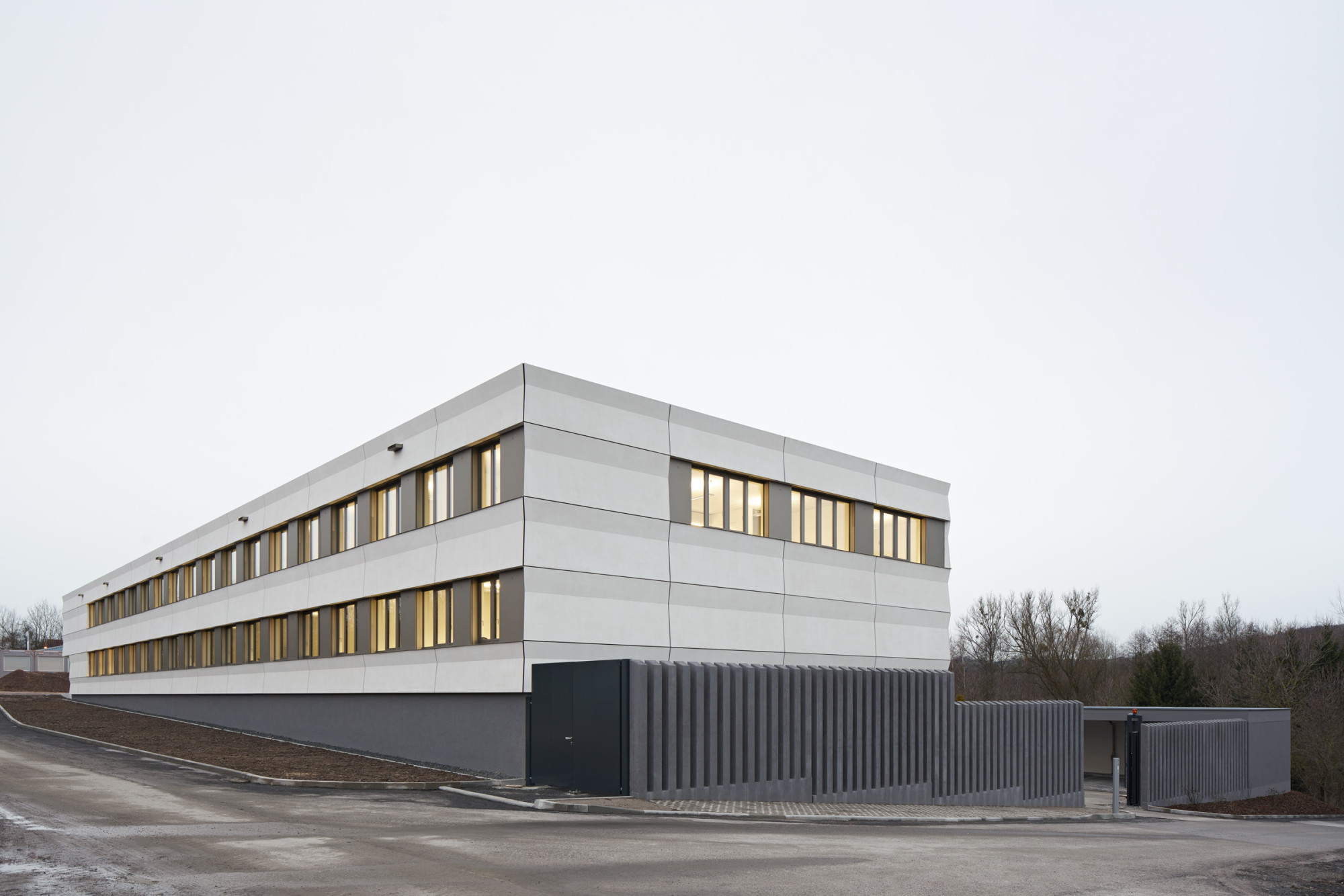 Im Nordosten begrenzen Betonstelen den Polizeihof. Dahinter befindet sich eine Rampe, über welche der tiefer gelegene Polizeihof erschlossen wird 