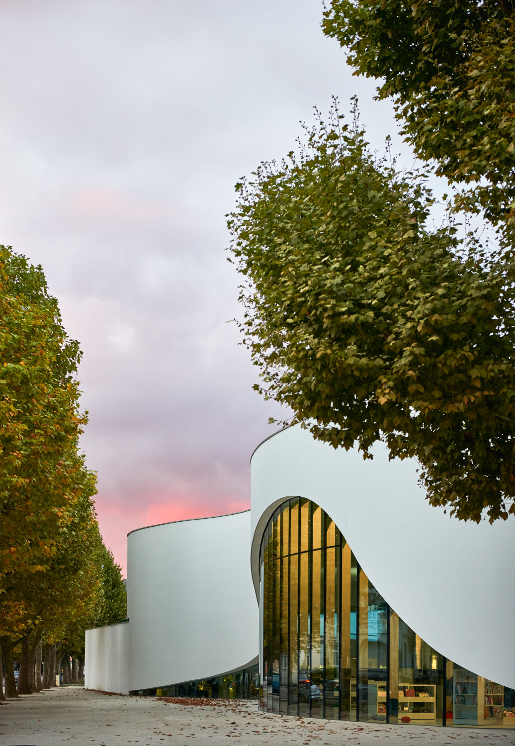 Je nach dahinter liegender Funktion oder Position im Grundriss variiert die Breite des Bandes. Eine darunter angeordnete Pfosten-Riegel-Fassade mit filigranen Profilen bildet eine schützende Membran zum Außenraum