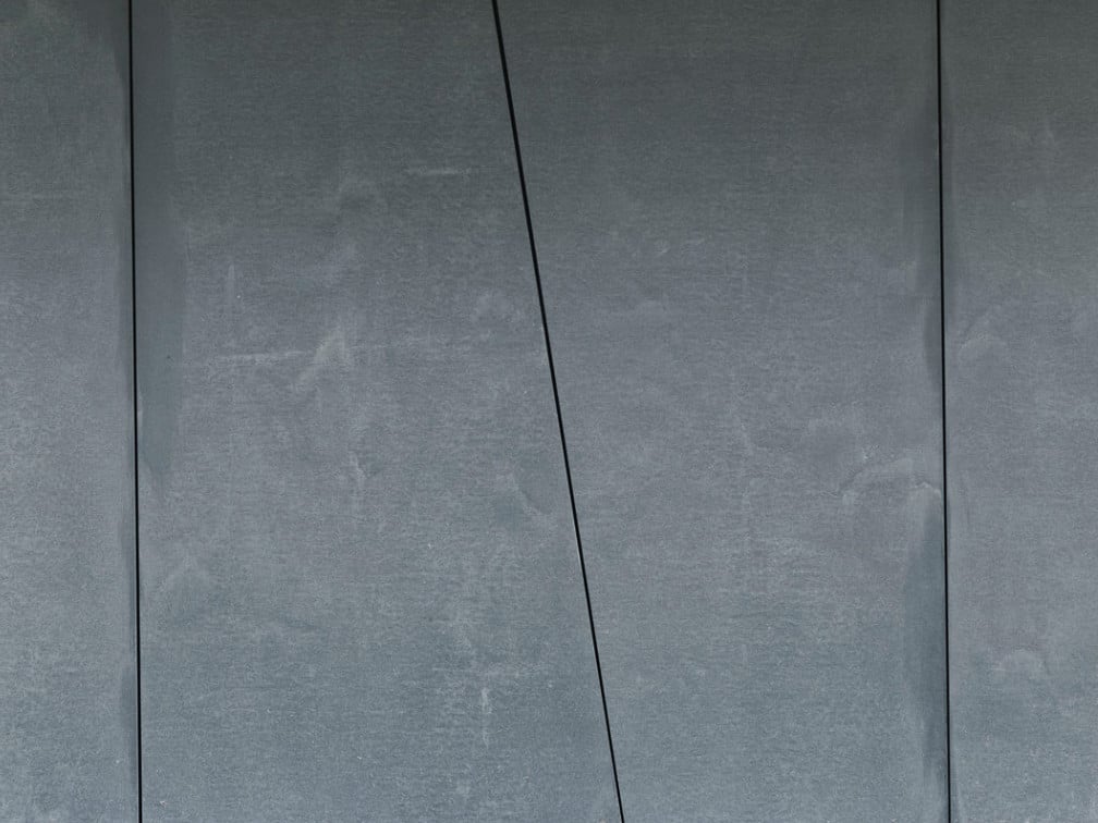 Im Erdgeschoss einer Wohnanlage in Kirchberg (Tirol) beispielsweise kommen 13 Millimeter dünne, anthrazitgraue Paneele der Produktreihe Concrete Skin mit der Oberfläche Vintage zum Einsatz (Architekt: Franz Obermoser, Kitzbühel)