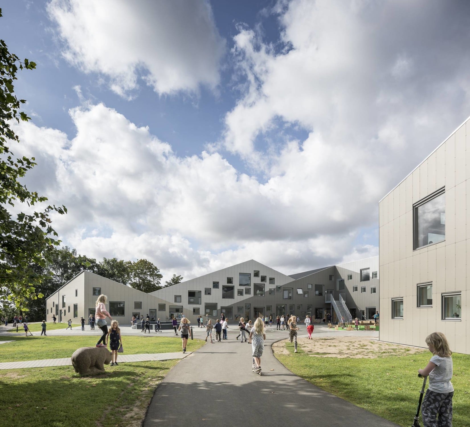 Spielerisch in die aluminiumbekleidete Fassade eingestreut wirken die verschieden großen, quadratischen Fenster