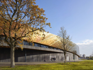FaulknerBrowns Architekten aus dem britischen Newcastle Upon Tyne schufen ein weit ausschwingendes Bauwerk mit einem prägnanten metallischen Band als oberem Gebäudeabschluss