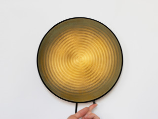 Der Designer David Derksen montiert für seine Moiré Wall Light zwei drehbare Lochscheiben hintereinander, mit LEDs auf der Rückseite
