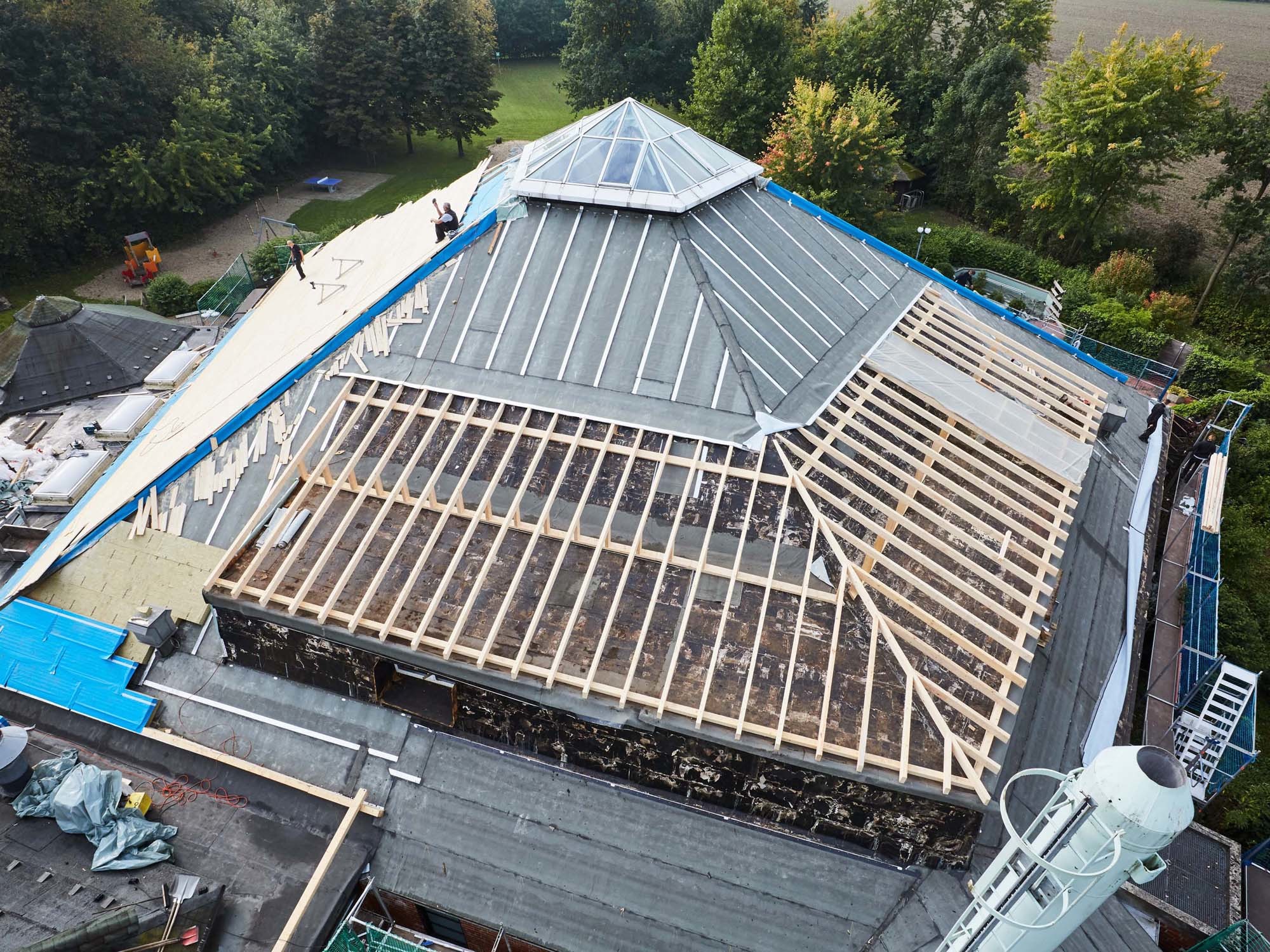 Das alte Dach wurde bis auf die Holzkonstruktion demontiert, nur die Lichtkuppel verblieb auf der Spitze