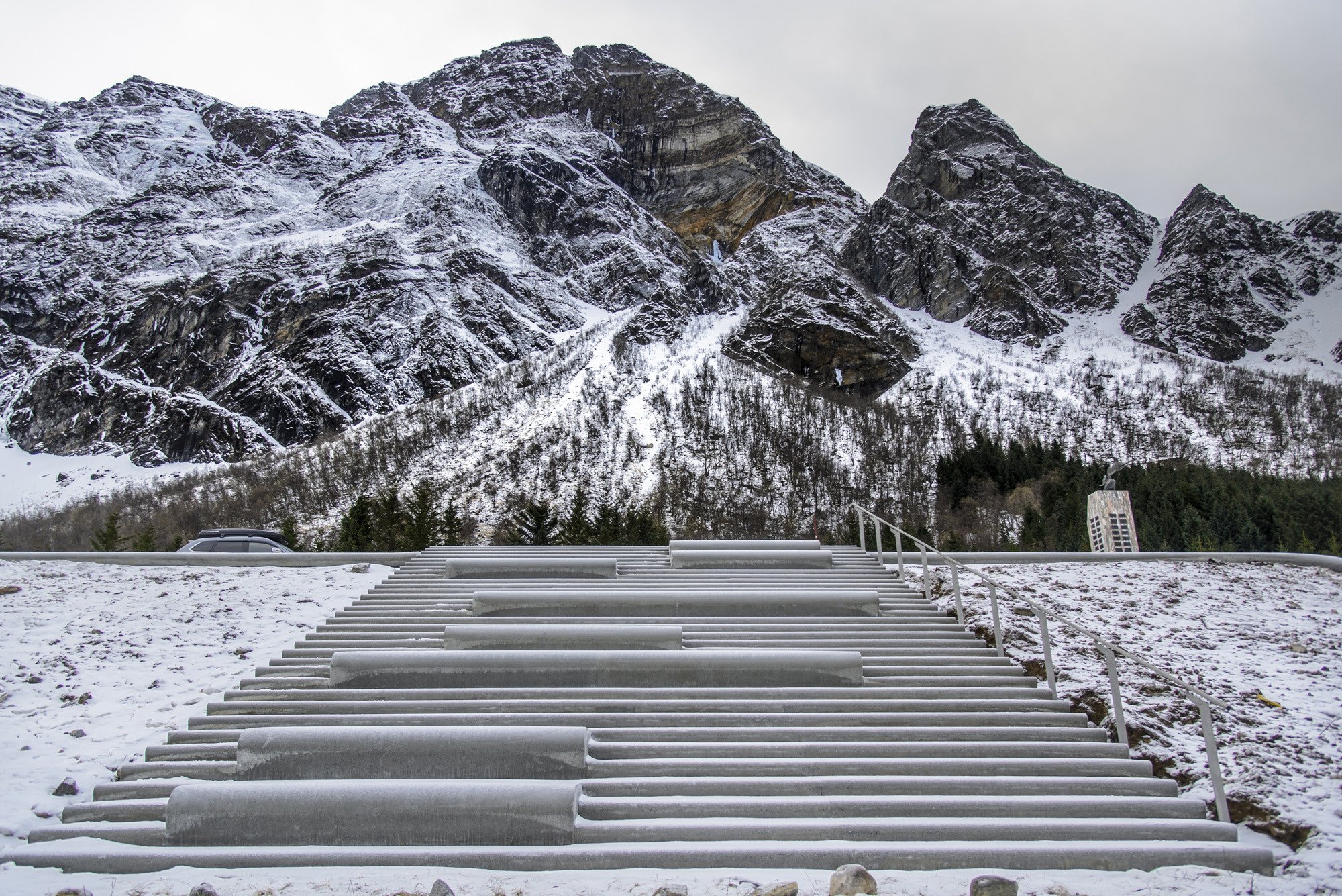 Eine Betontreppe führt zum Strand, wulstartige Sitzstufen laden zum Verweilen ein