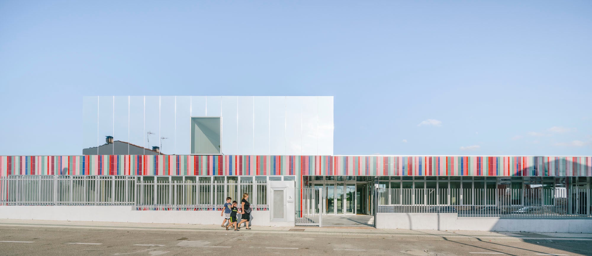 Die zweigeschossige Grundschule mit angegliedertem Kindergarten entstand auf einem Grundstück, das dreiseitig von Straßen begrenzt wird