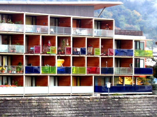 Farbige Glasgeländer an den Balkonen eines Mehrfamilienhauses