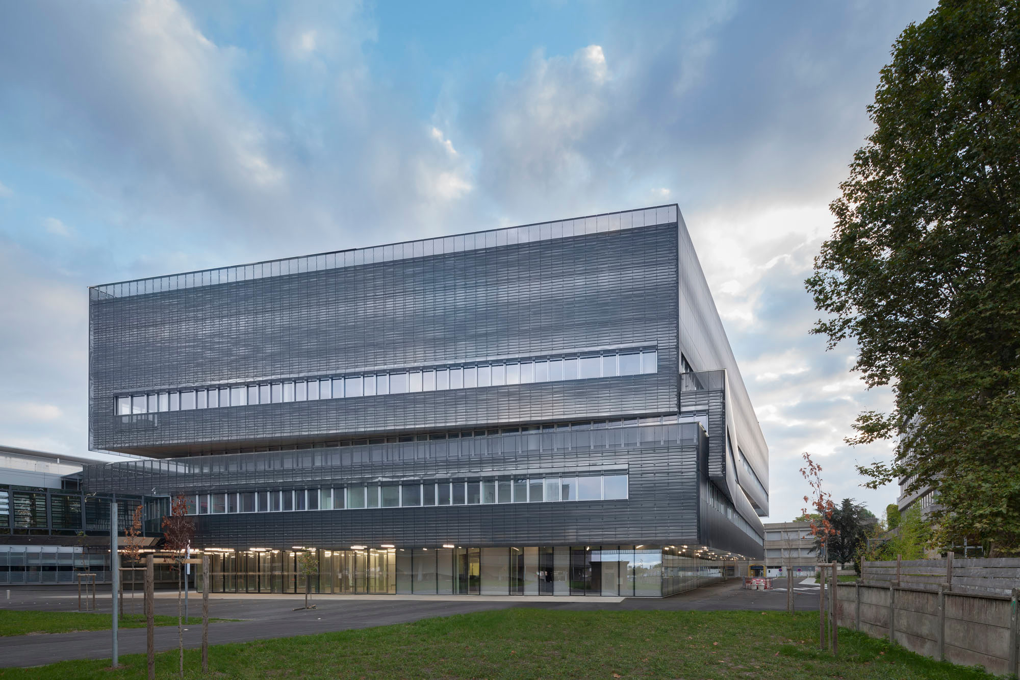 Durch eine geringfügige Drehung der Geschosse und die daraus resultierenden abweichenden Gebäudekanten nahmen die Architekten Bezug auf die Nachbarschaft (westliche Eingangsseite)