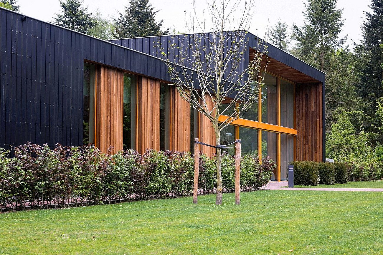 Große Teile der Fassade, die Attiken und Übergänge der Flachdächer sind mit dunklem Ebenholz bekleidet