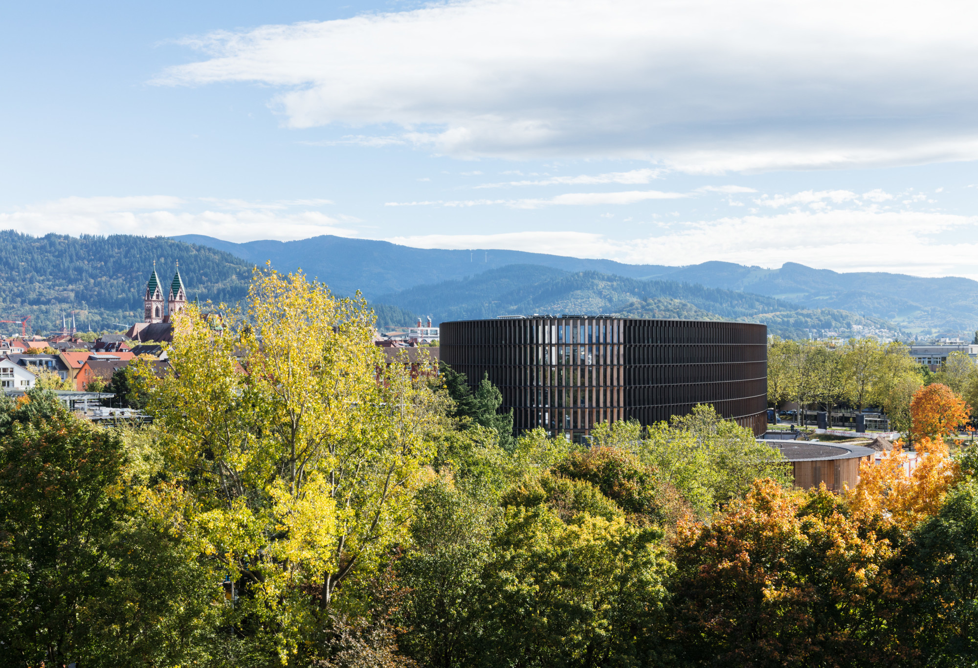 Sechs Geschosse hoch, liegt der Neubau in einem Grünraum zwischen dem Freiburger Universitätsklinikum und einem Stadtpark