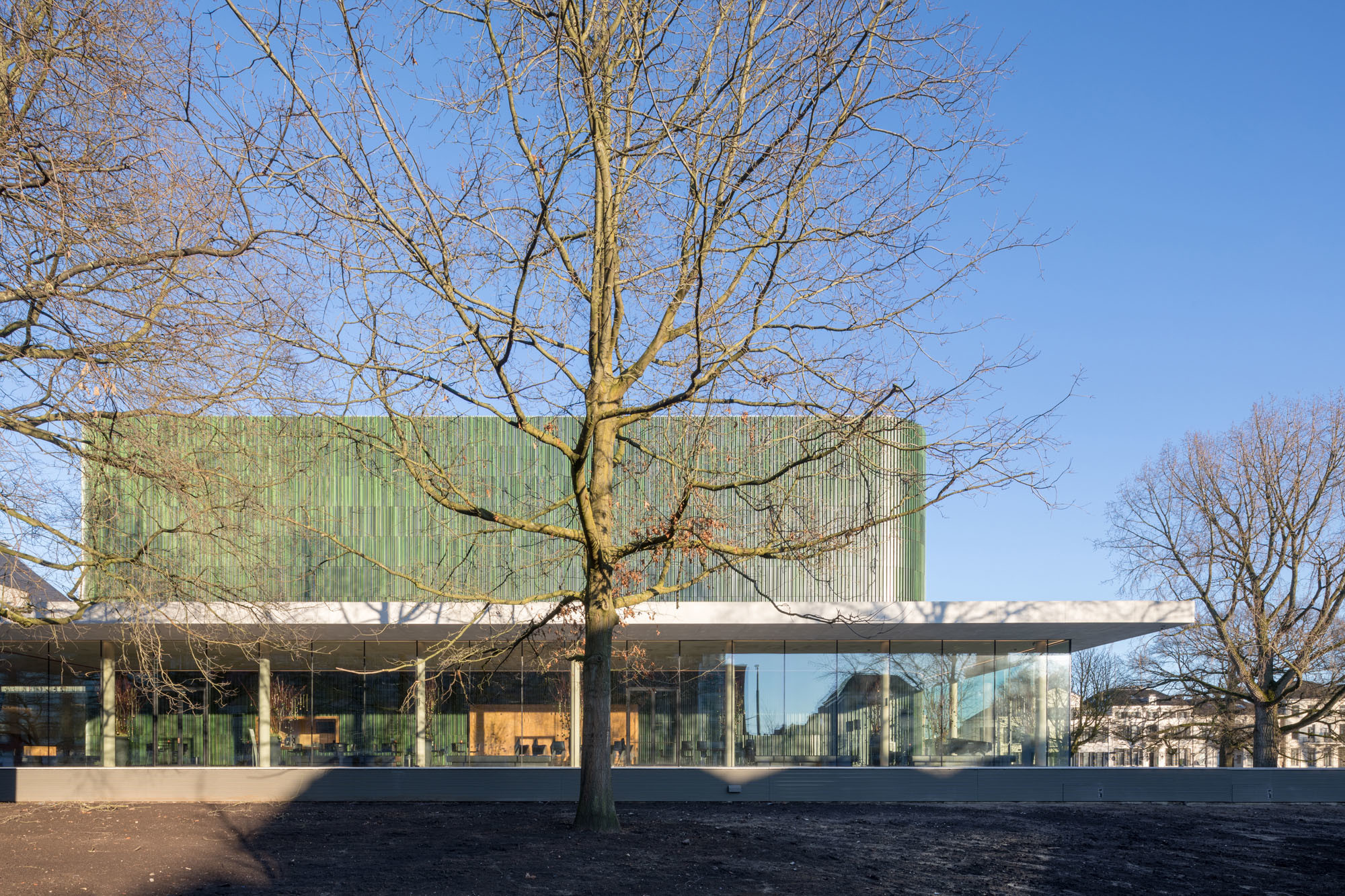 Die changierend grüne Keramikfassade sorgt für die Einbindung in die Parklandschaft (Westseite)