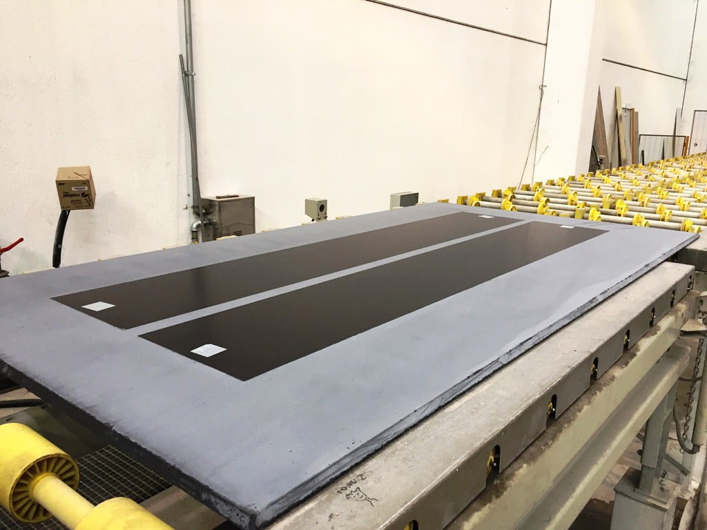 Auf dem Betonpaneel wirken die Solarfilmstreifen fast wie dunkle Verglasungen