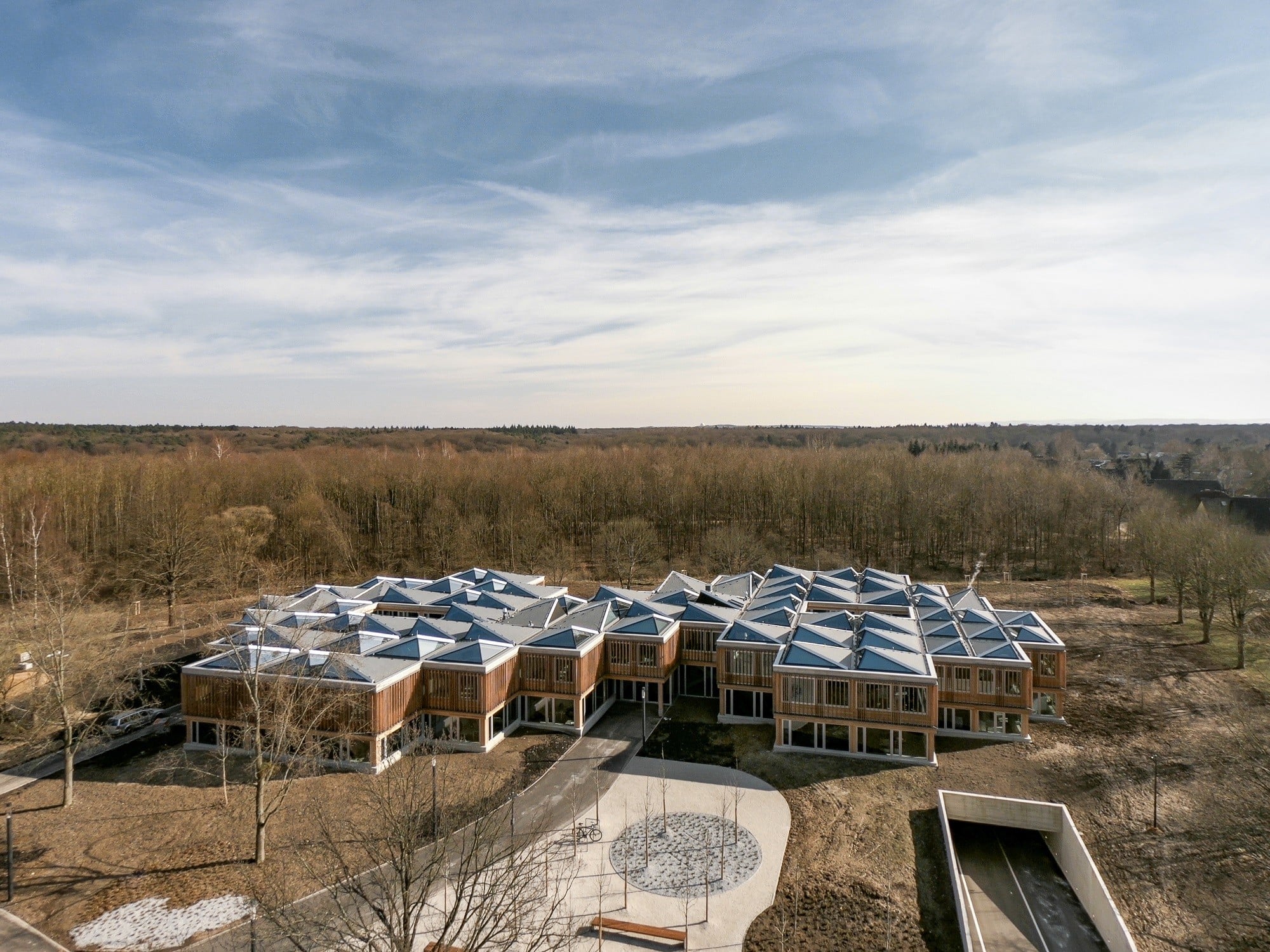 Die Darmstädter Architekten Waechter + Waechter entwarfen das zweigeschossige Bauwerk, dessen im Grundriss zumeist quadratischen Module wie Cluster um zwei Innenhöfe gruppiert sind.