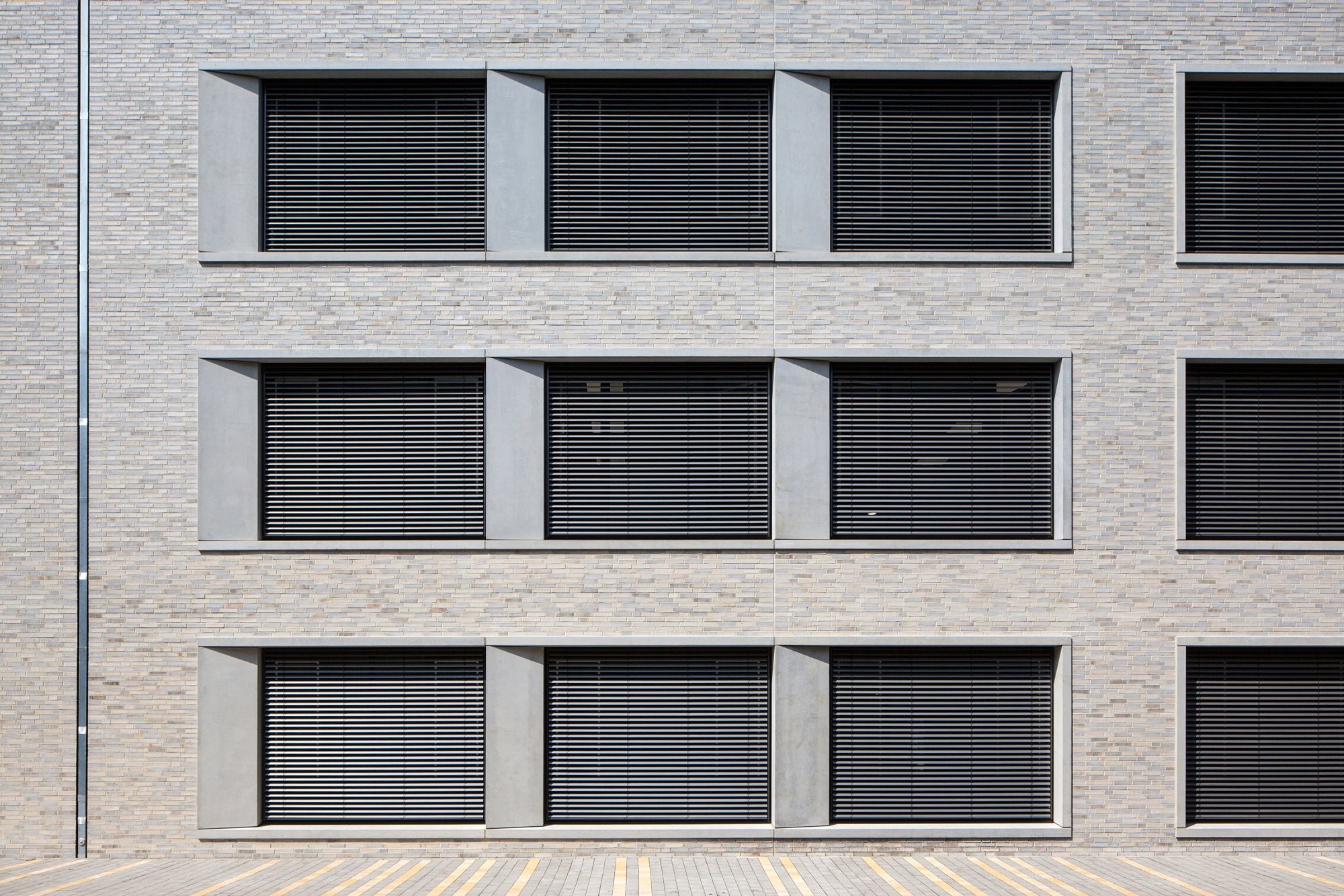 Die Fensterlaibungen sind Sichtbetonfertigteile, eine Seite ist betont und verläuft schräg.