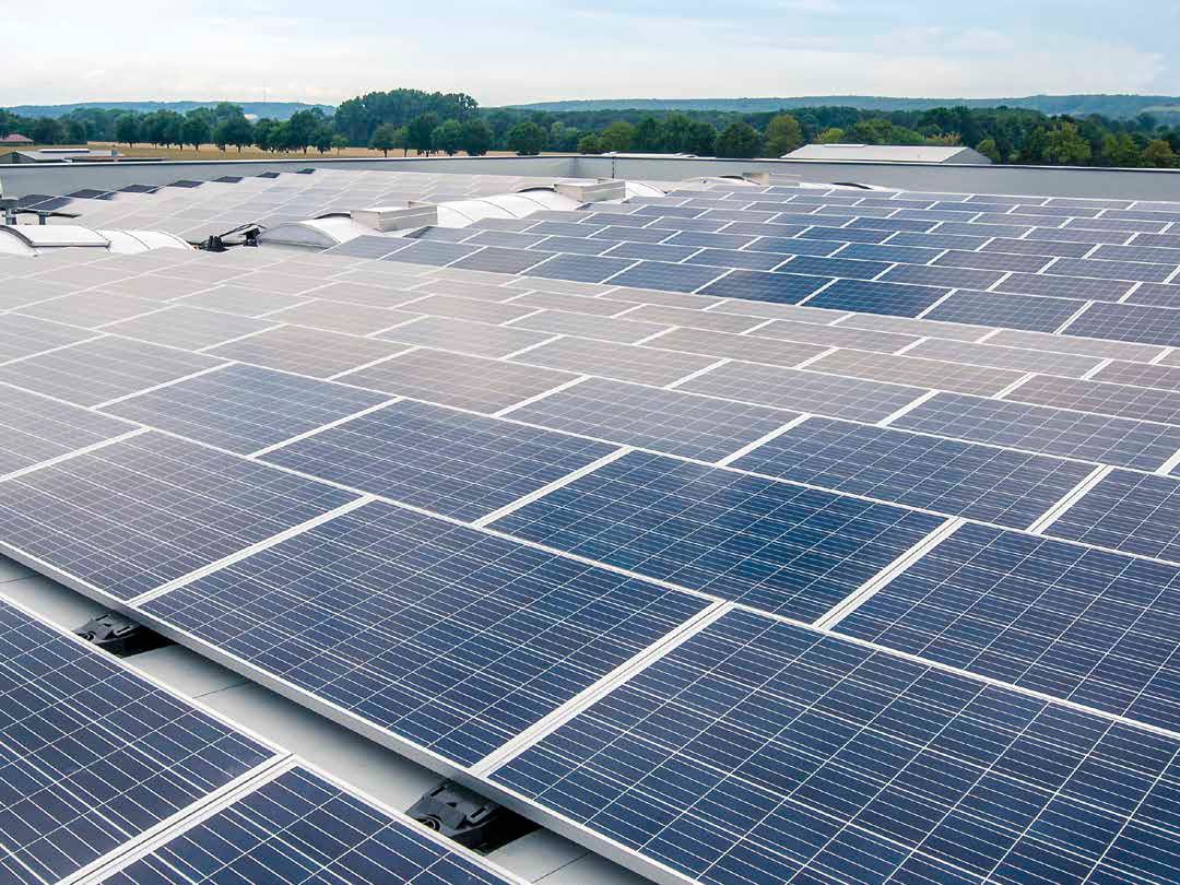 Bei großen Flachdächern bietet sich eine Installation von Solarpaneelen an, um einen umweltfreundlichen Gebäudebetrieb zu unterstützen und langfristig Kosten zu sparen.