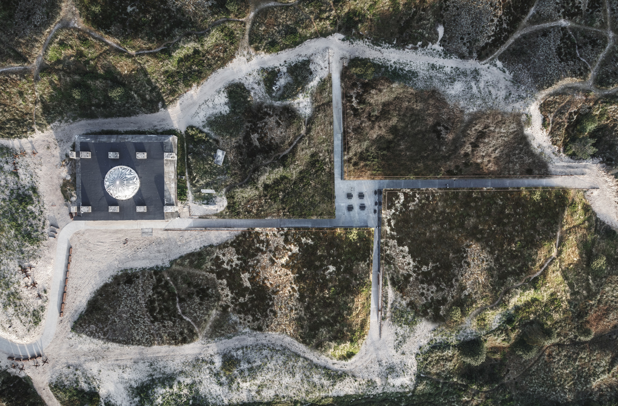 Aus der Luft: Das Ausstellungshaus nach Plänen der Bjarke Ingels Group ergänzt einen Bunker und ist eingebettet in die Dünenlandschaft.