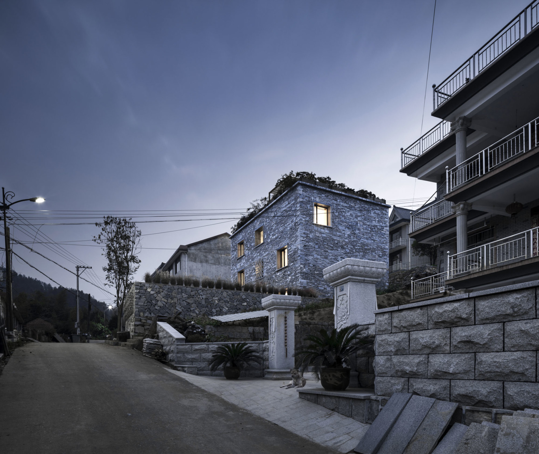Anders als die Nachbarhäuser ist der dreigeschossige Bau, den Zhang Lei von AZL Architects aus Nanjing plante, ein schlichter Quader mit einem bepflanzten Flachdach. 